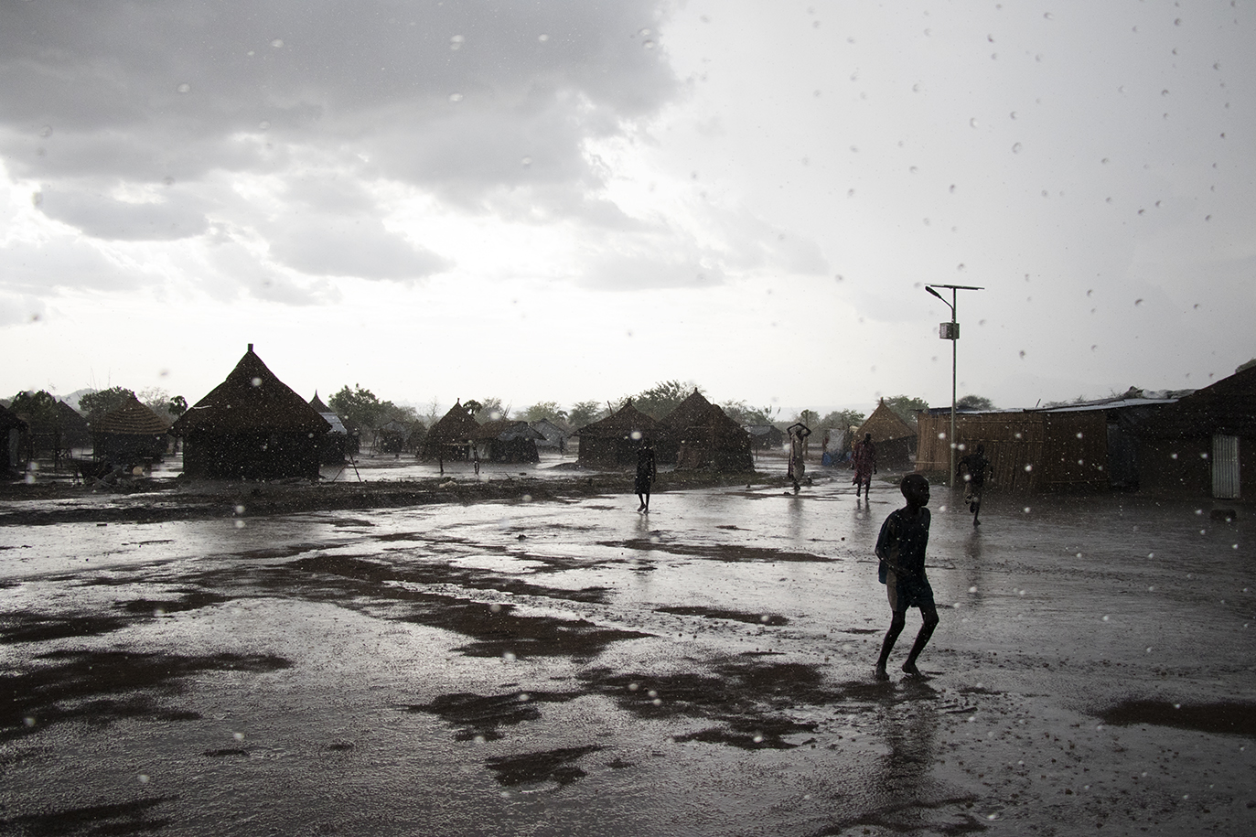 Children enjoying a rare rainfall in Nyumanzi refugee camp.
