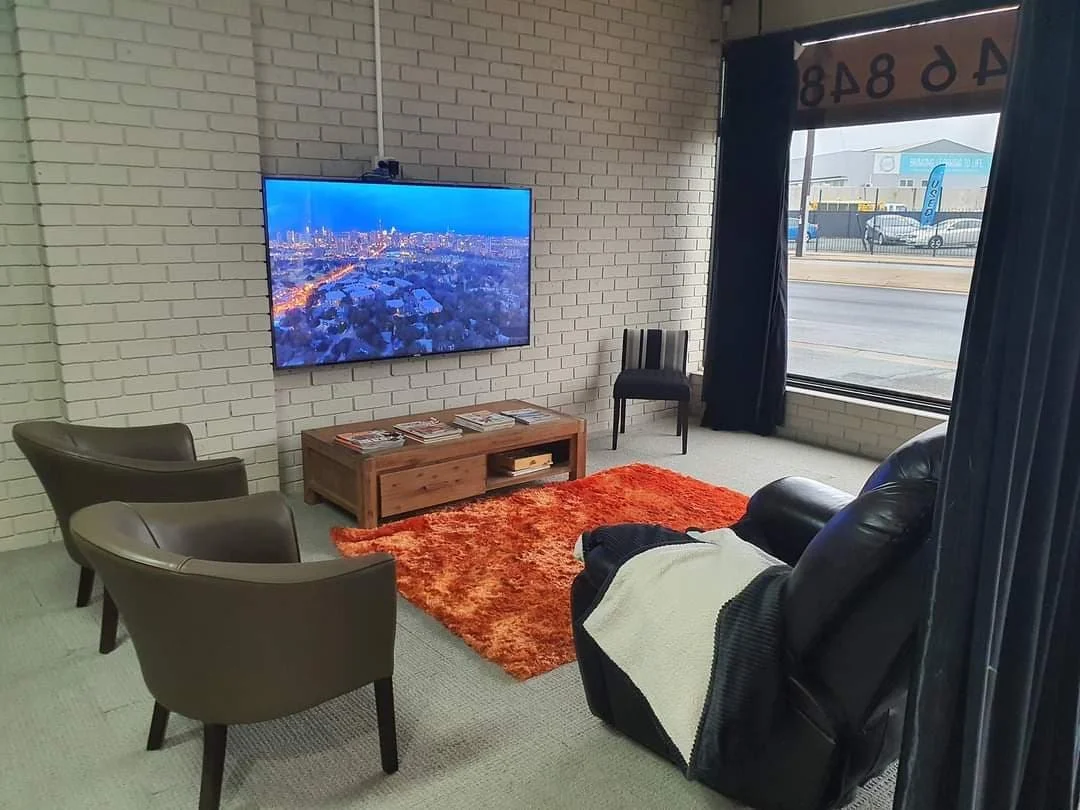 Fusion Tinting client lounge with recliners, TV and coffee table