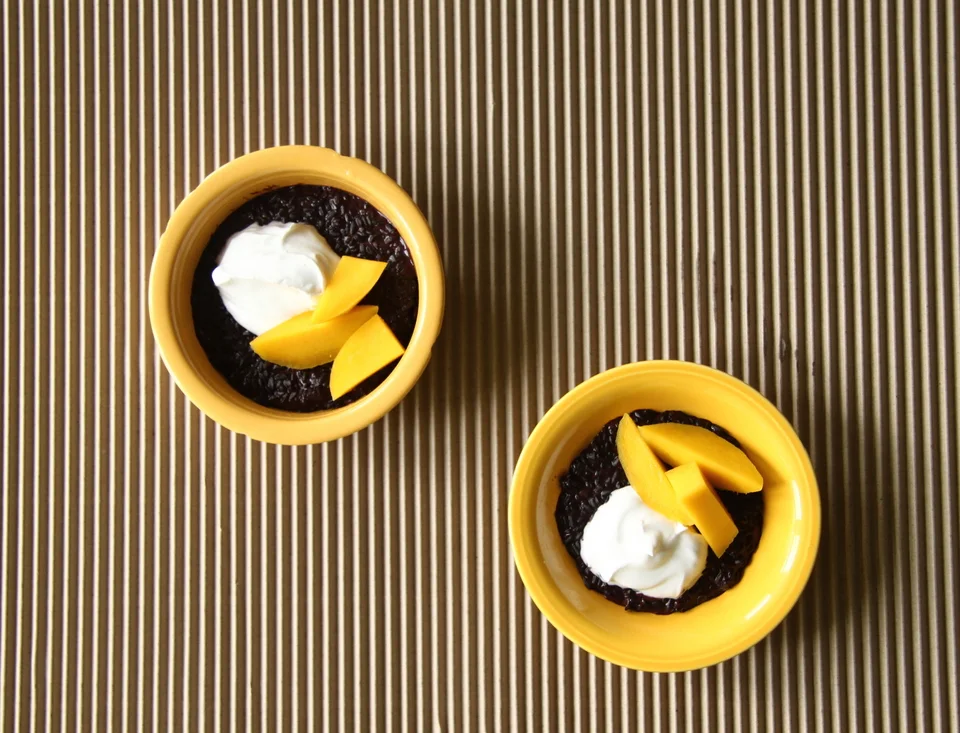 Black rice porridge, coconut yogurt, mango . Cook a couple of handfuls of black rice (it doesn’t increase in volume like processed rice does), and the same amount of water to a pan and bring to the boil. Once boiling, reduce the heat to low and add a pinch of salt. Cook for about 20-30 minutes until the rice is tender and you have a mass of dark, purple, witchy looking porridge. Here you stir in a little milk (soy/coconut) and a touch of honey . Serve with coconut yoghurt and slices of fresh mango.
