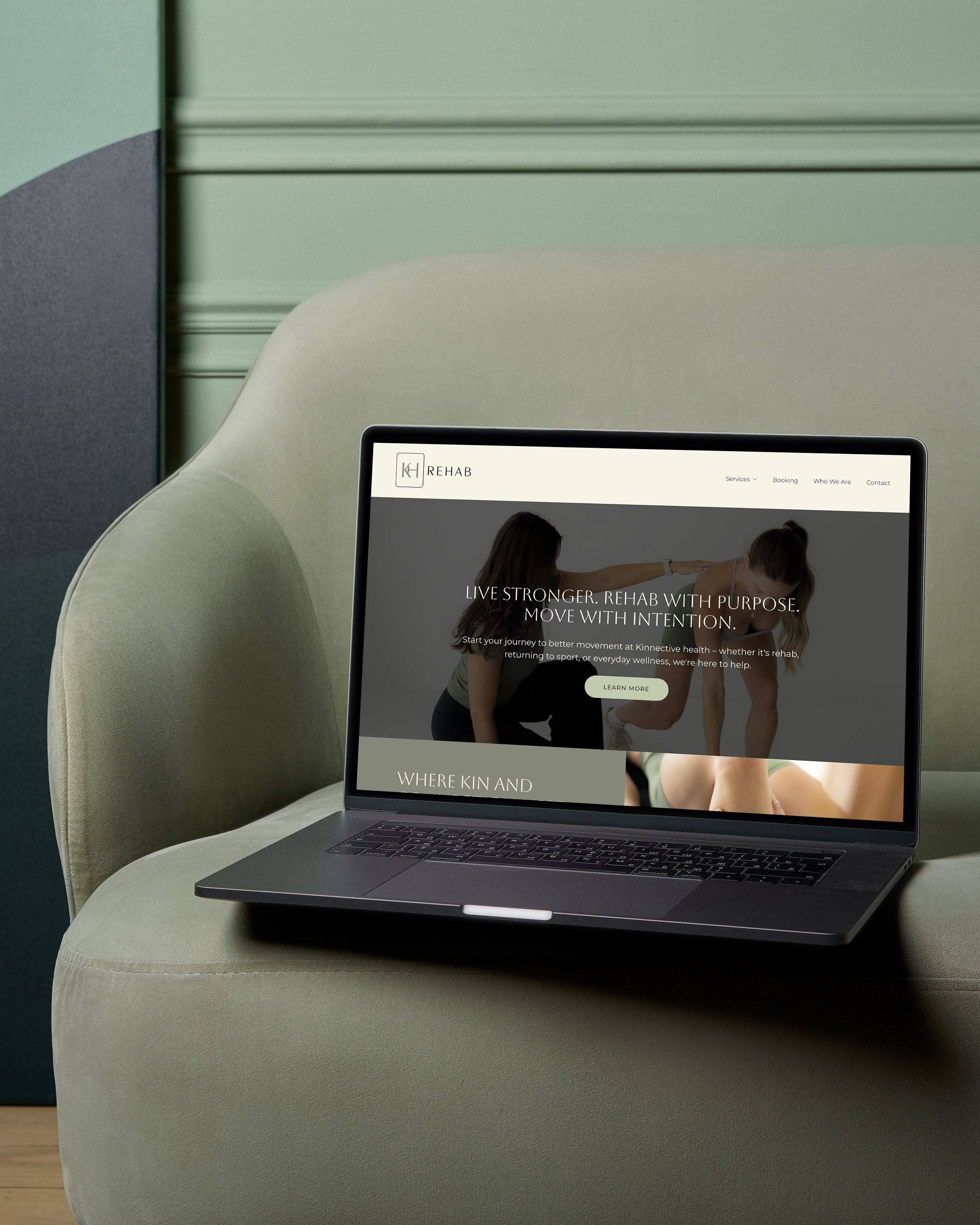 Laptop on olive-green chair displaying a rehab services website with an image of two women stretching, a logo, and navigation menu.