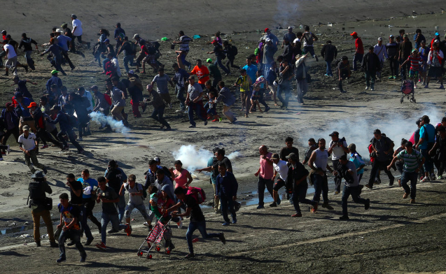 Migrants, including children, flee from tear gas used by US Customs and Border Protection agents at the border. REUTERS/Hannah McKay