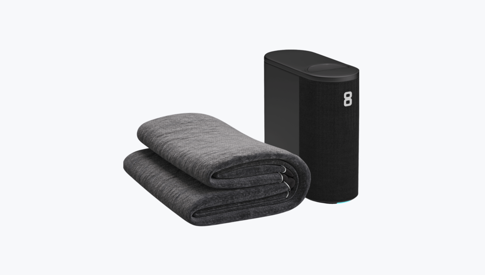 Eight Sleep Pro Pod cover. A grey blanket folded next to a black plastic box.
