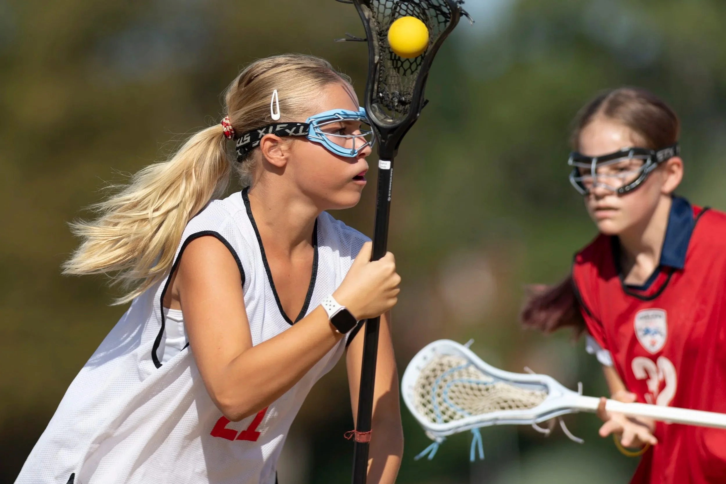 Player runs with yellow ball in black stick