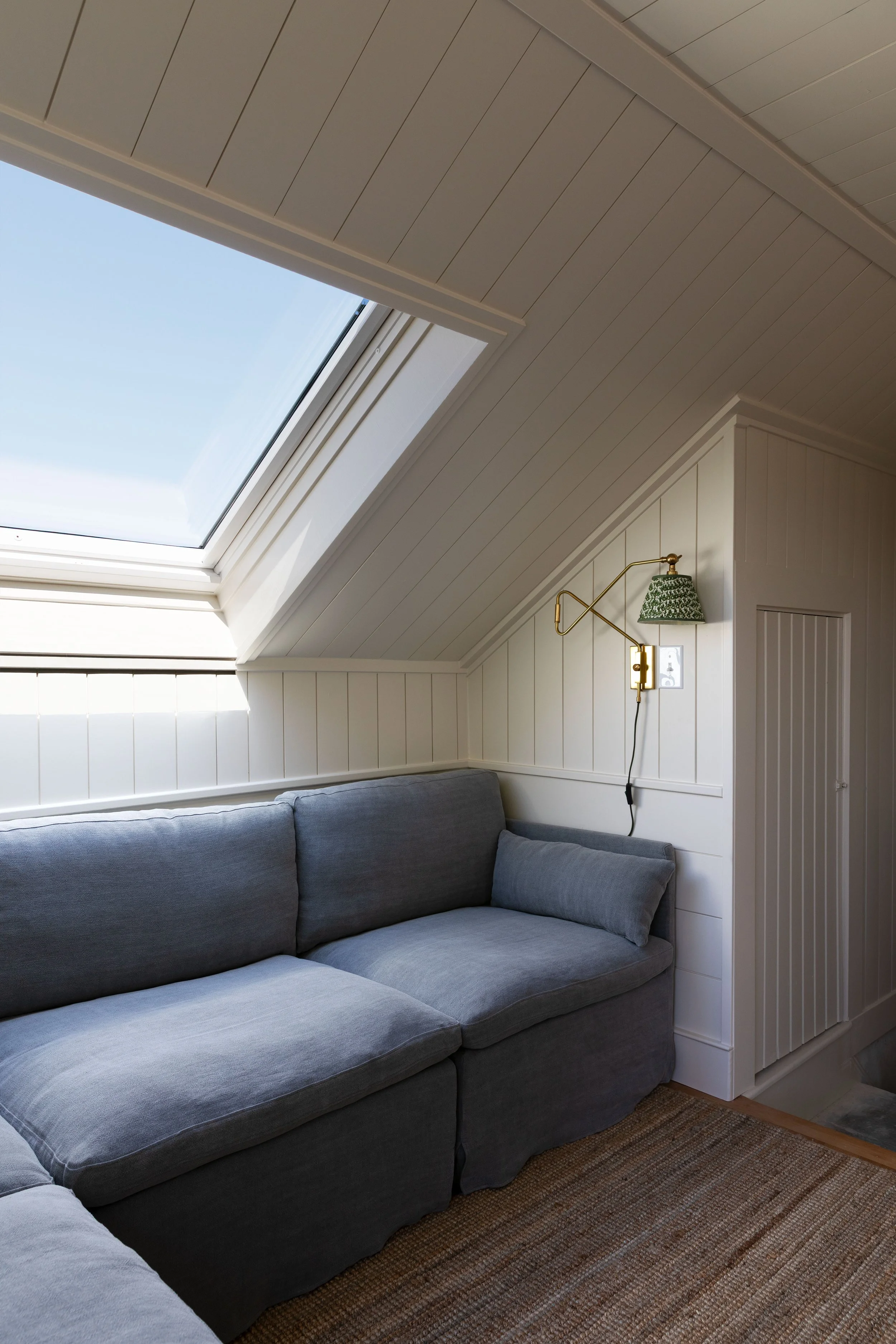 Small living room with pull-out reading sconce above a linen sectional sofa
