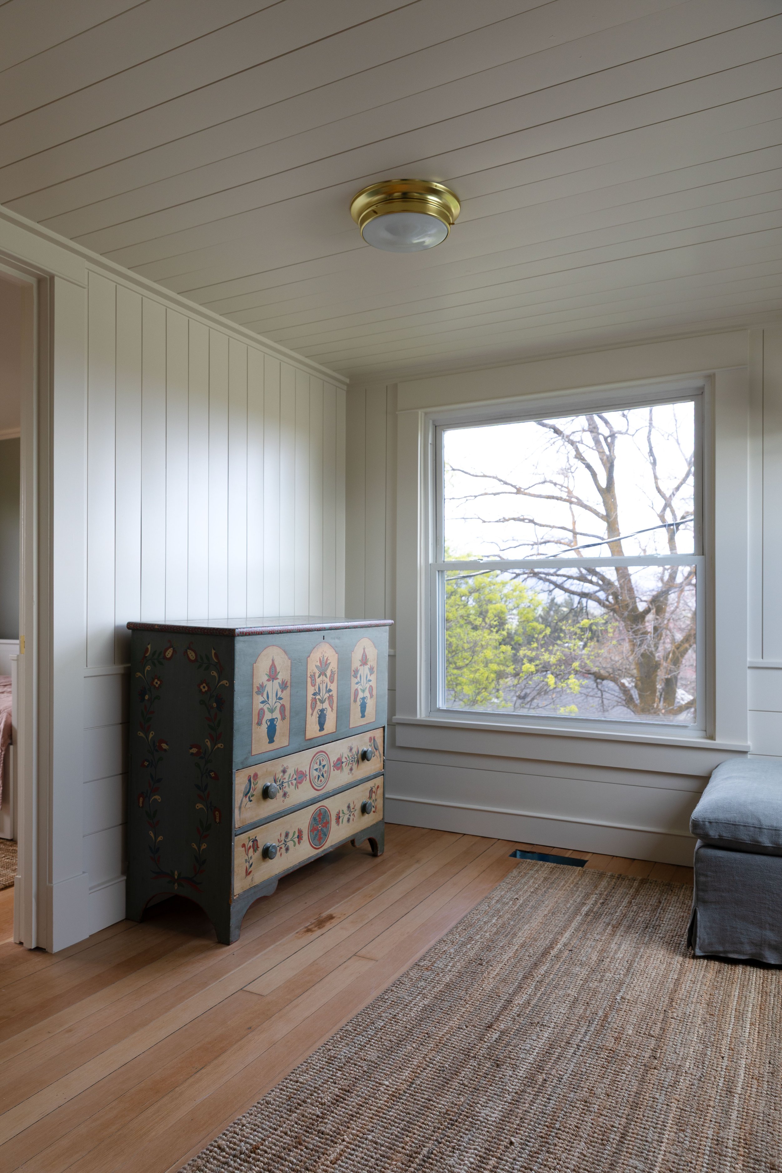 Vintage hand-painted dresser adding storage and character to a small upstairs snug