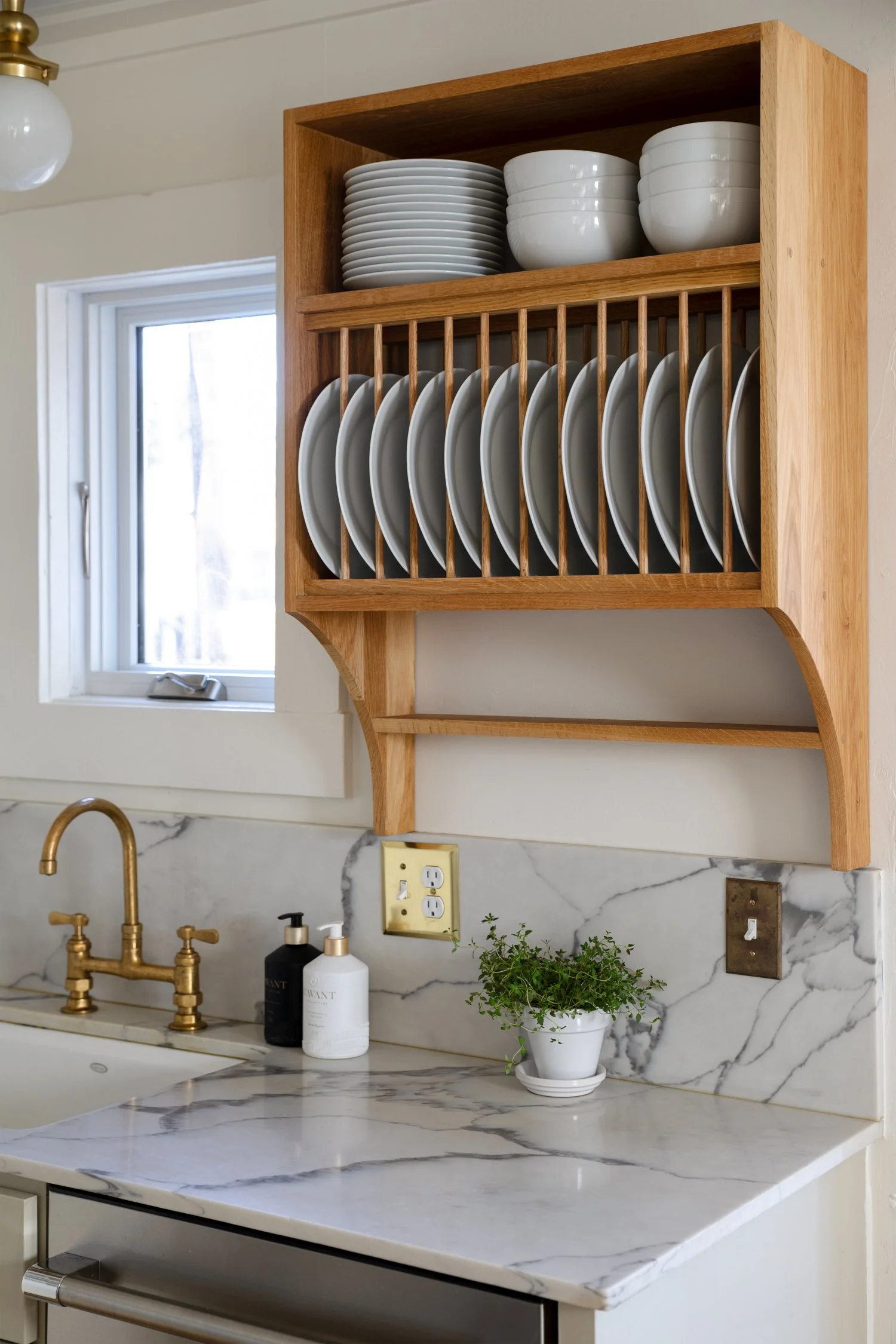 Angled close-up of wooden plate rack filled with plates and bowls.