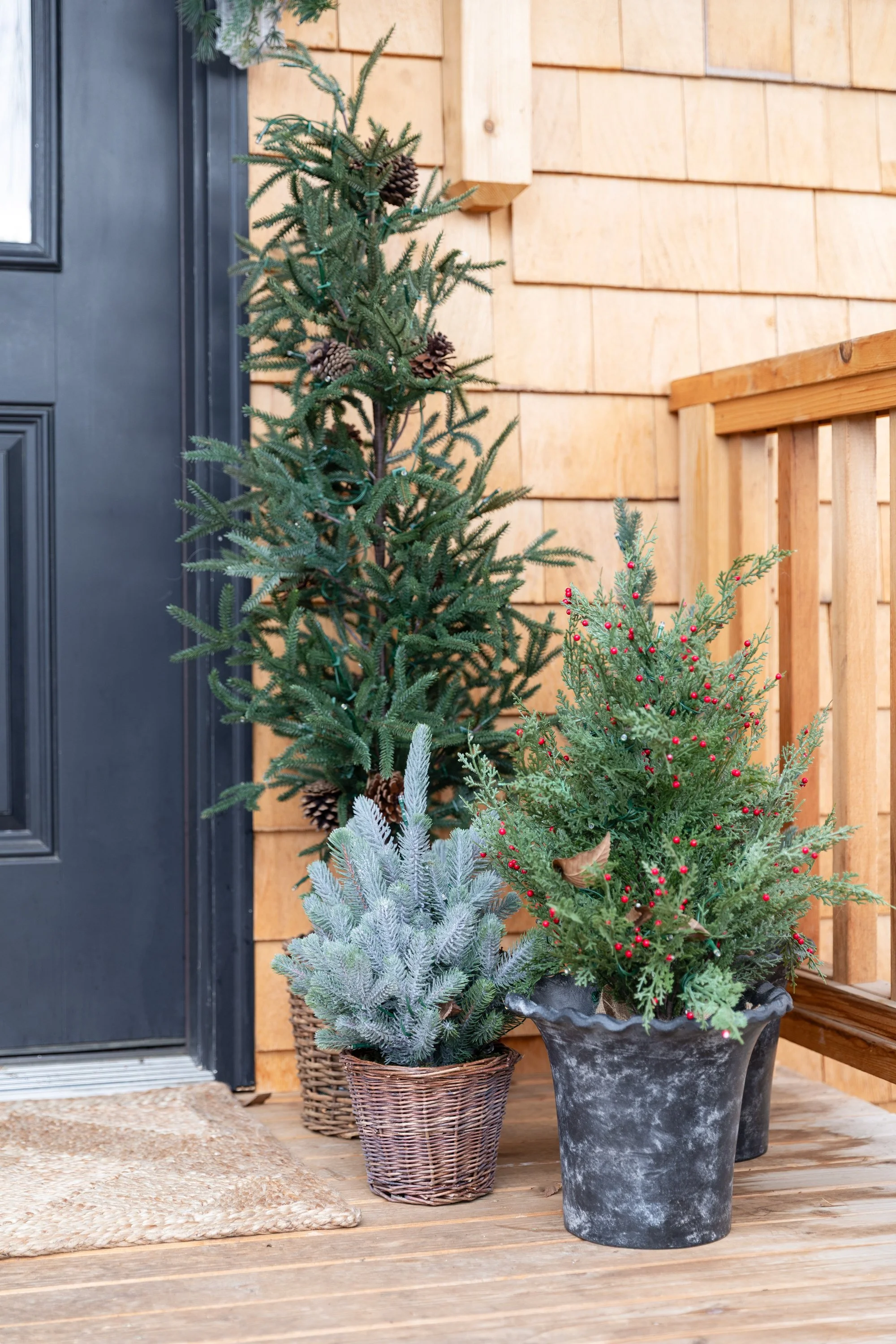 Faux evergreen trees in pots decorating the Poplar Cottage front deck