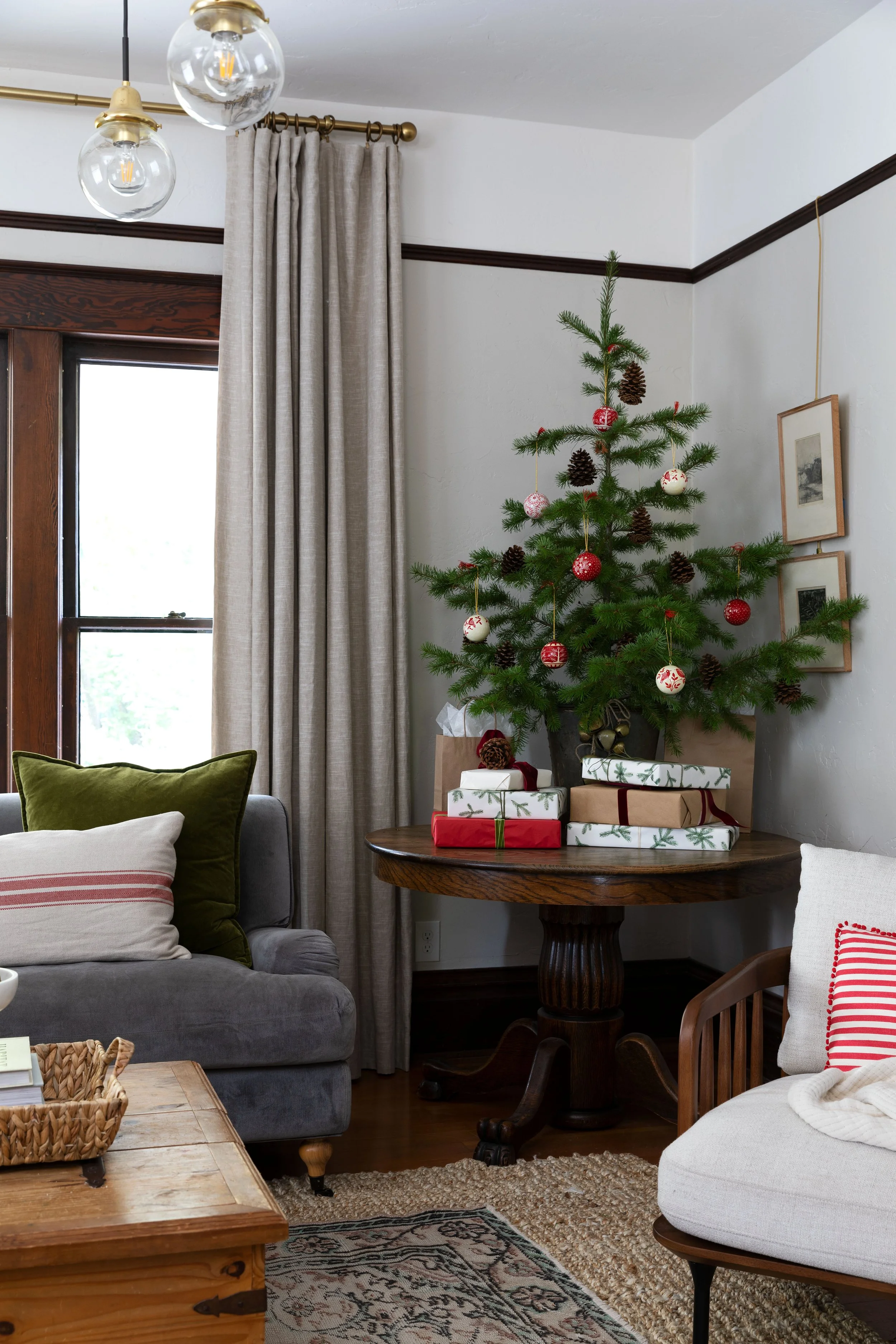 Historic farmhouse living room with a small Christmas tree on wood table.