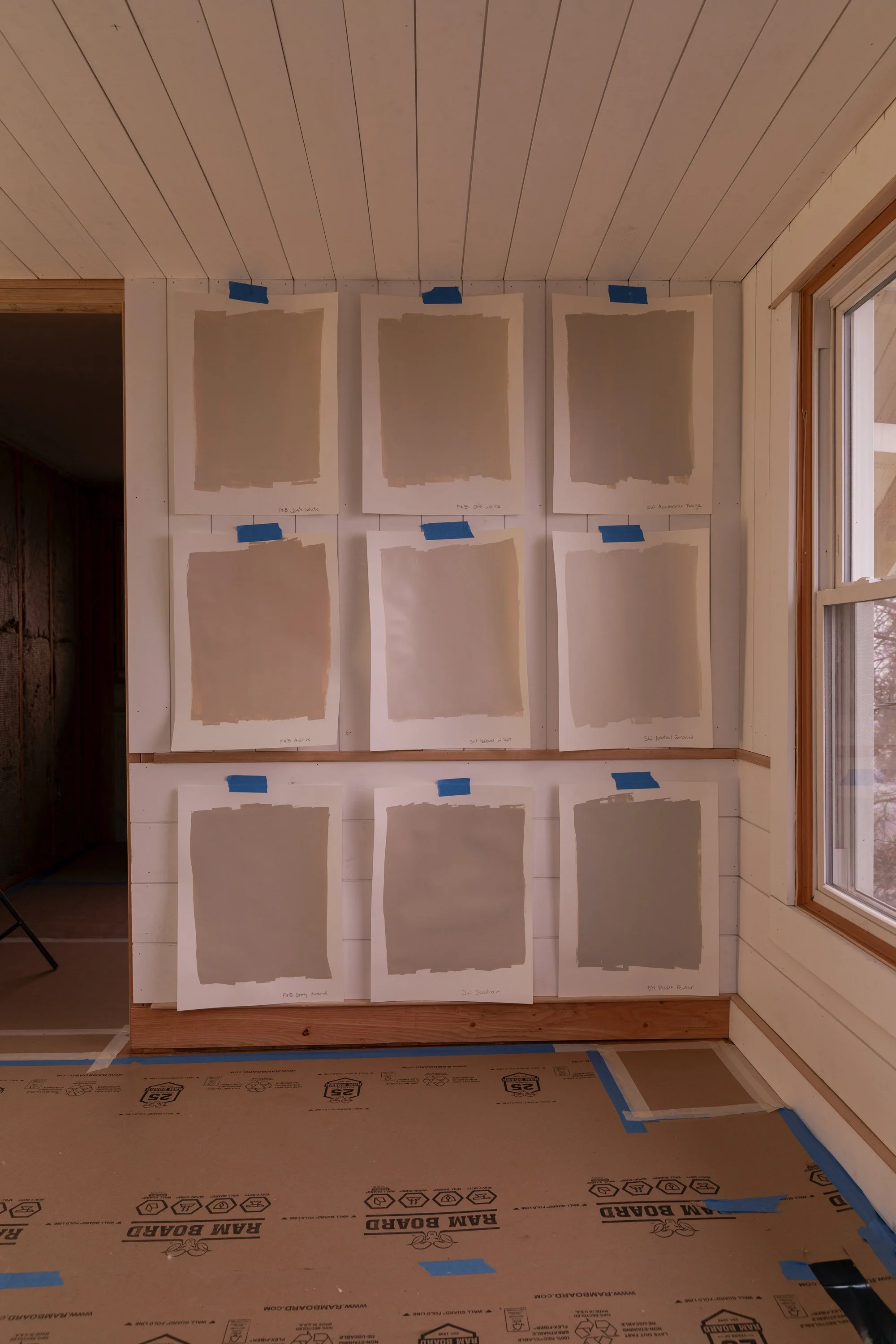 Warm neutral paint samples on planked walls shown in soft evening light to compare undertones