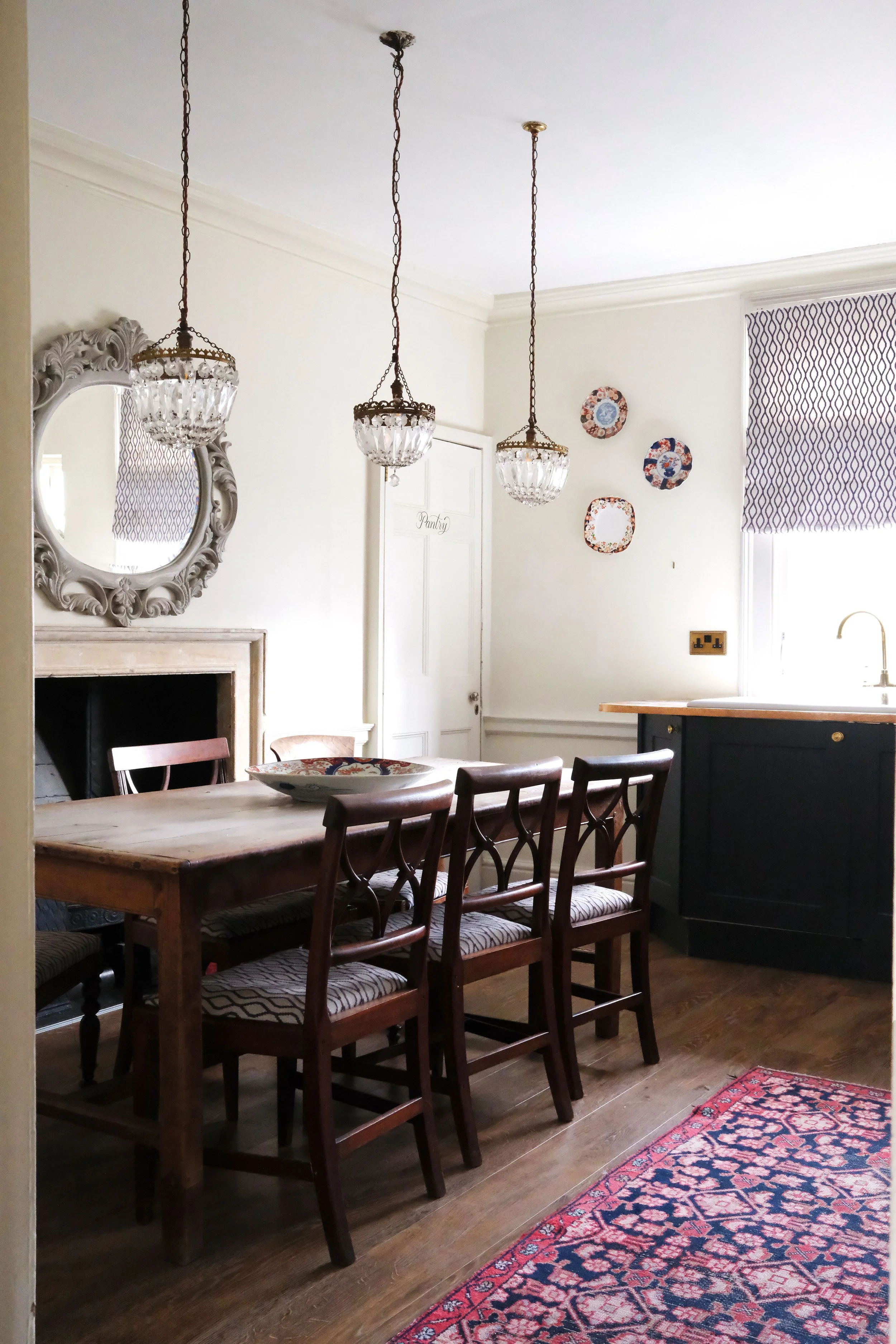Vintage dining table and mismatched wood chairs in a historic Bath apartment kitchen