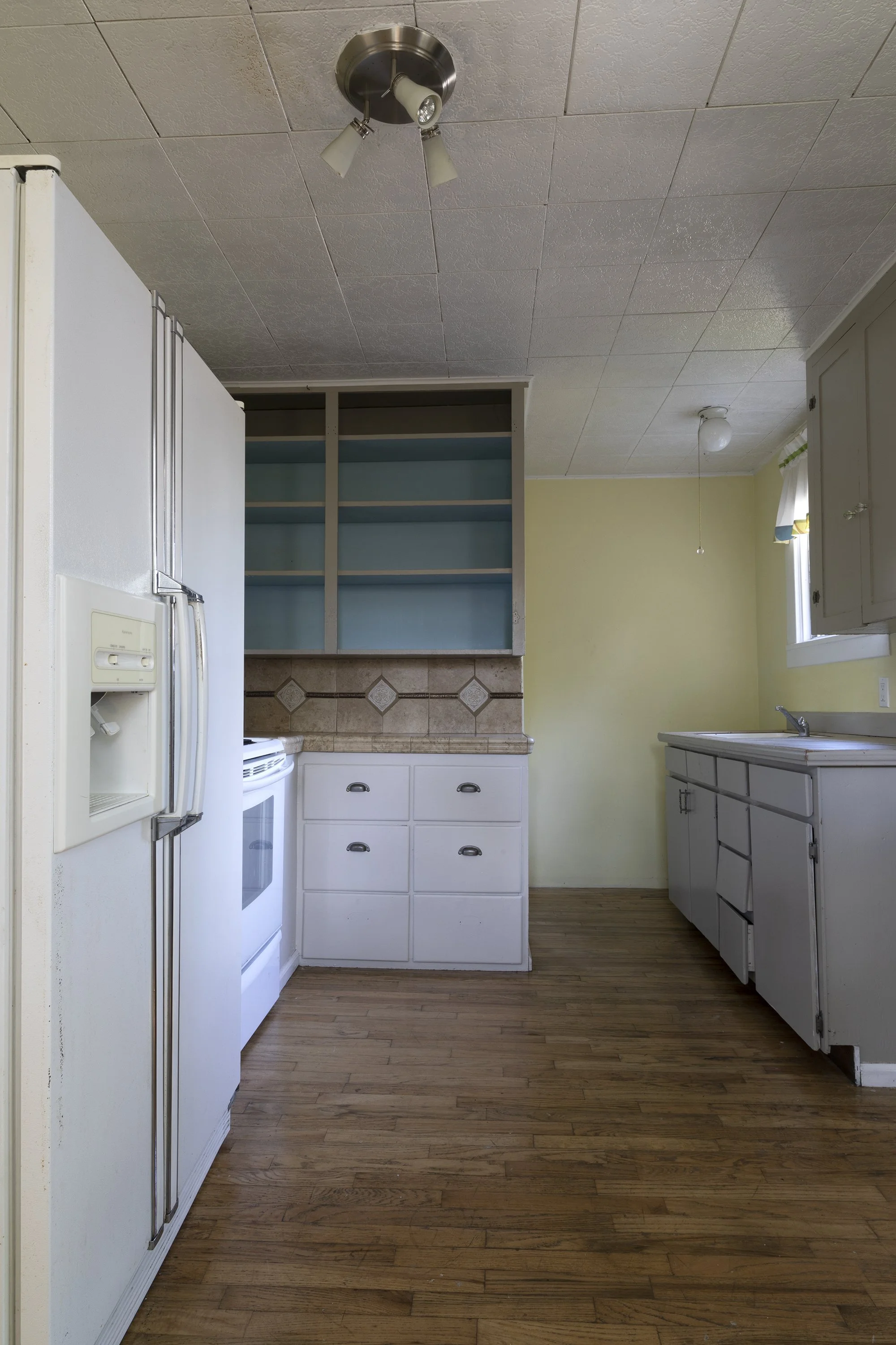 Close-up of original Poplar Cottage kitchen cabinets before the remodel.