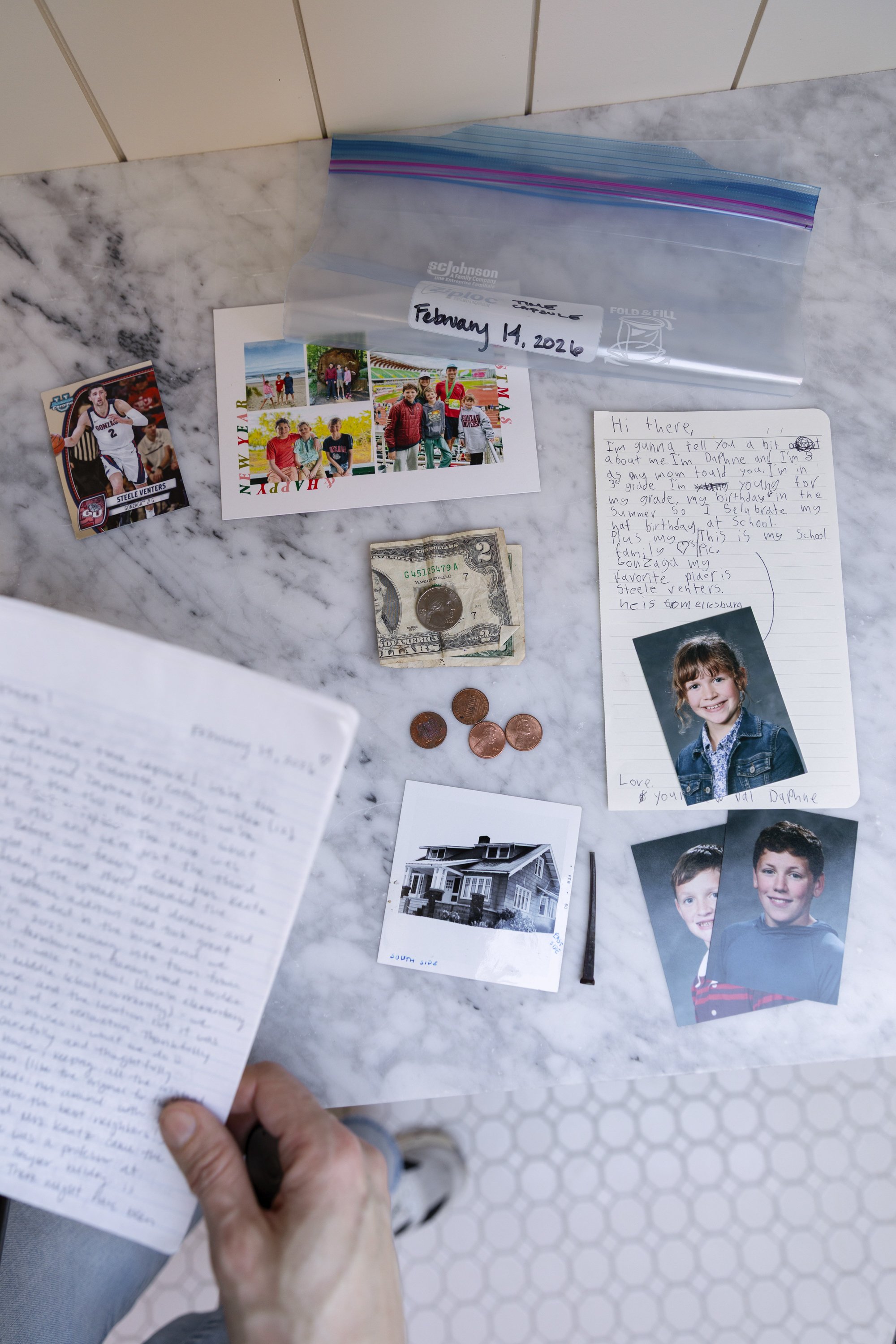 Hiding a time capsule in the Hill House renovation with a personal letter, money, pennies, a holiday card, basketball card, school photos, and a square ail
