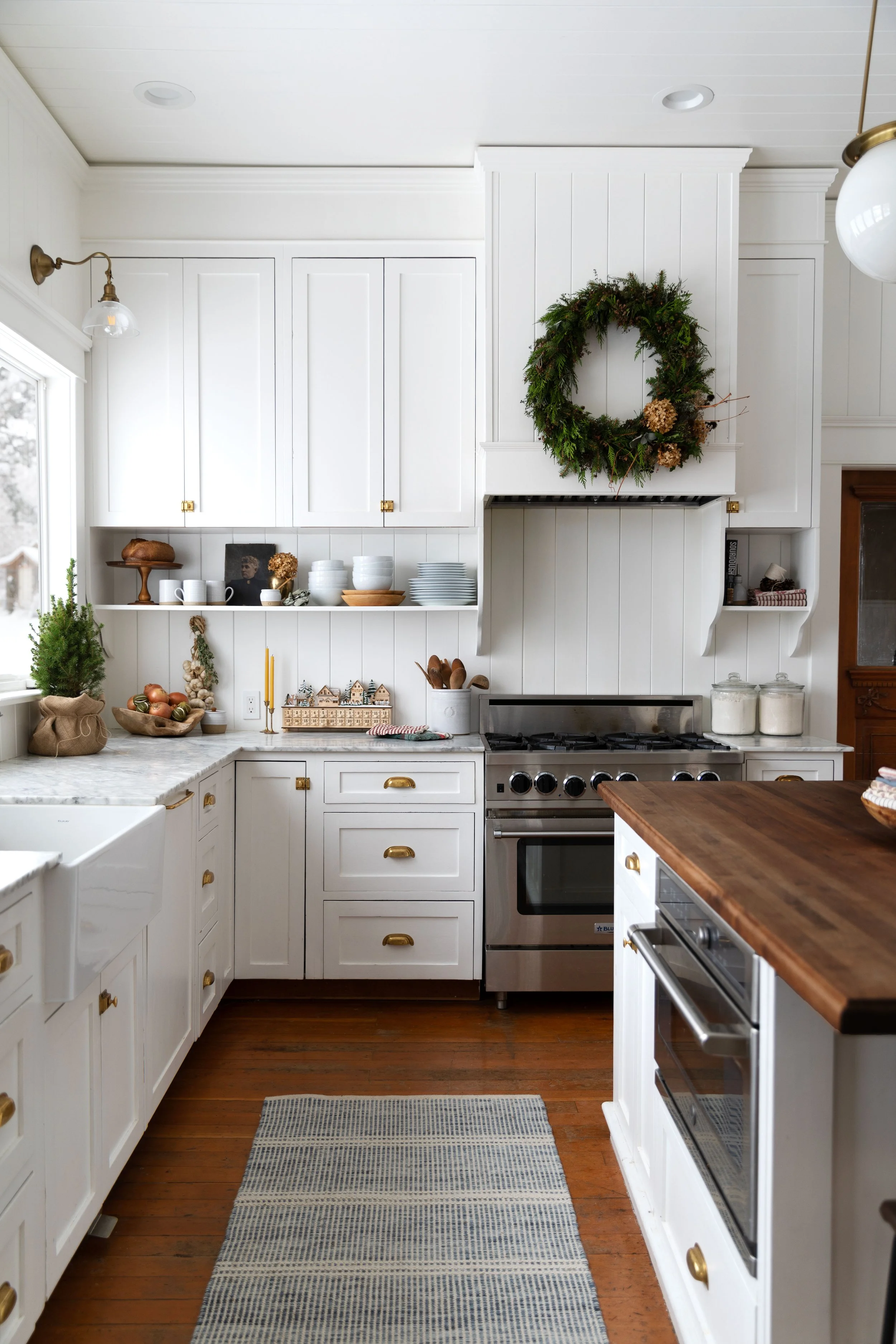 Warm farmhouse kitchen decorated for Christmas with greenery, advent calendar, and handmade holiday touches.