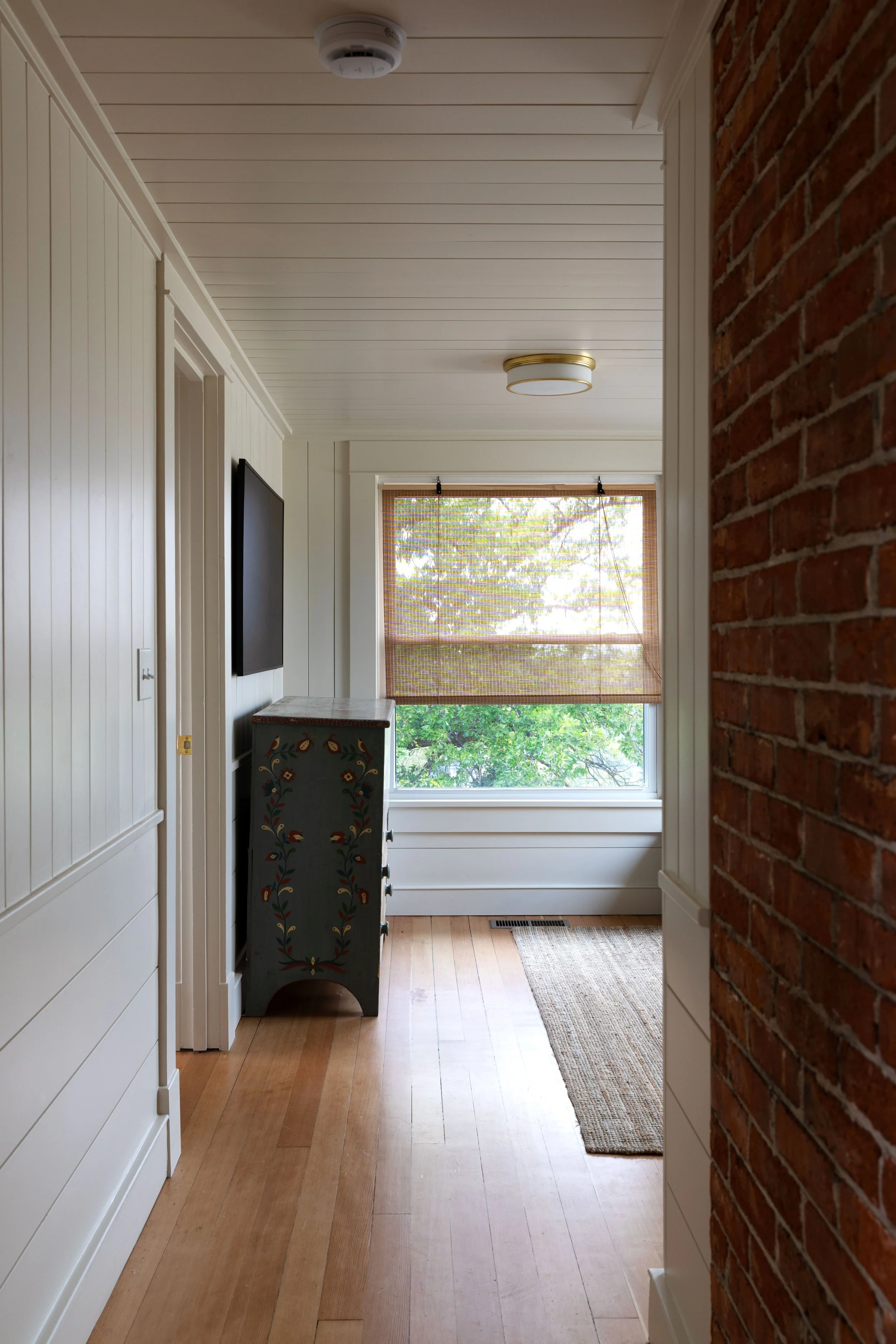 Renovated paneled upstairs hallway opening into the small Hill House snug