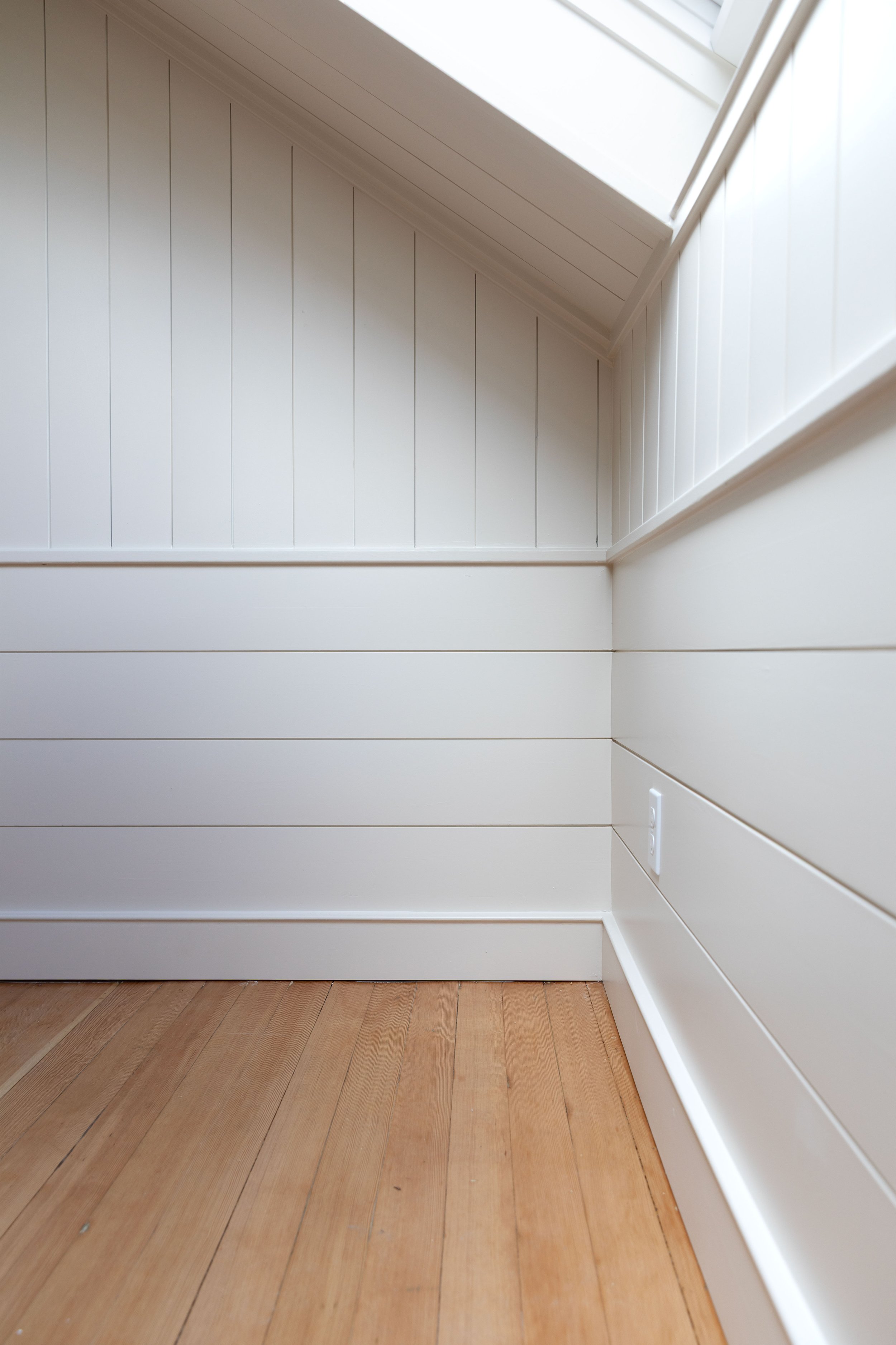 Horizontal and vertical paneling with sloped ceilings in the Hill House snug renovation