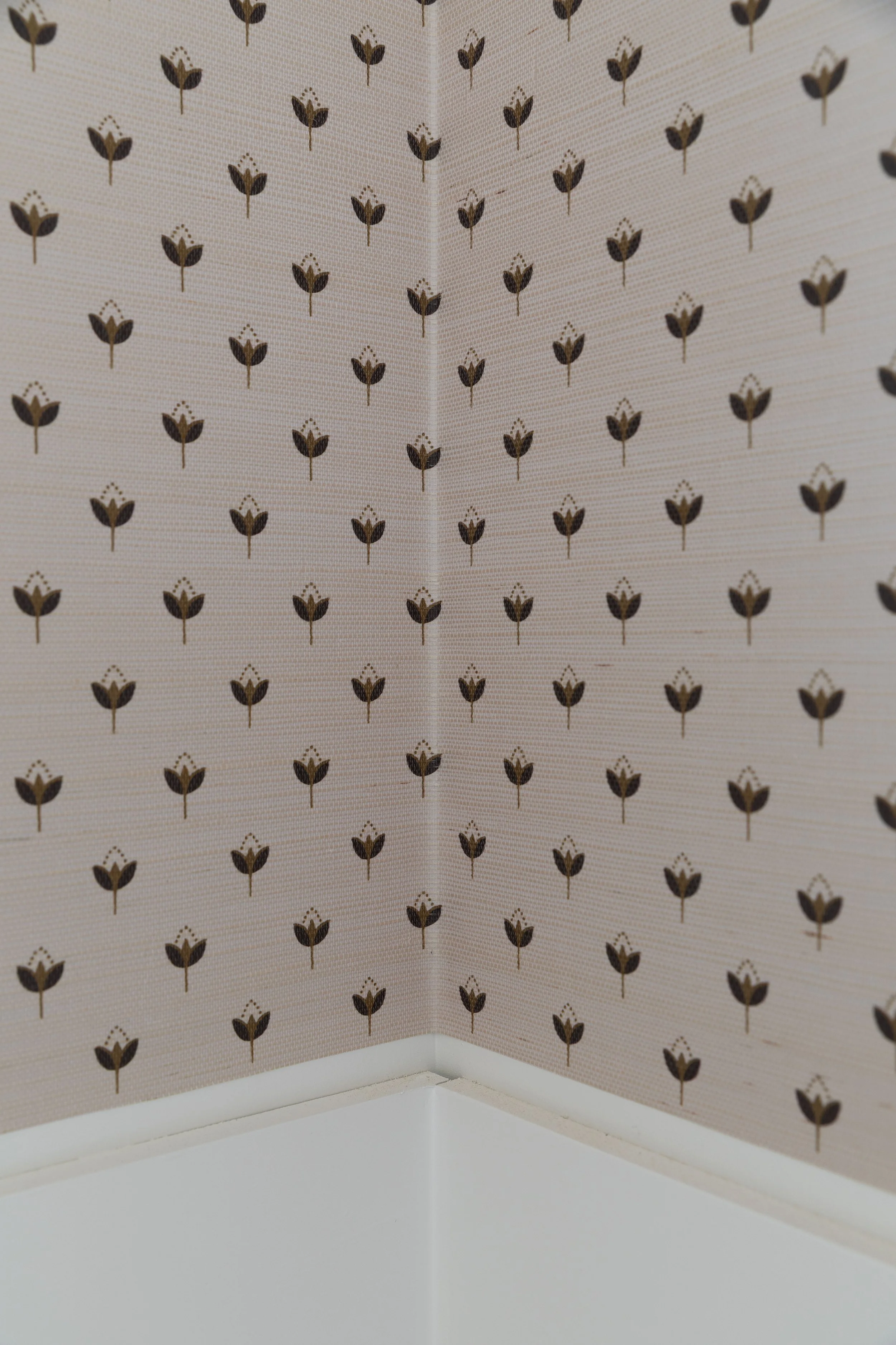 Detail of grasscloth wallpaper wrapped and trimmed at an inside corner
