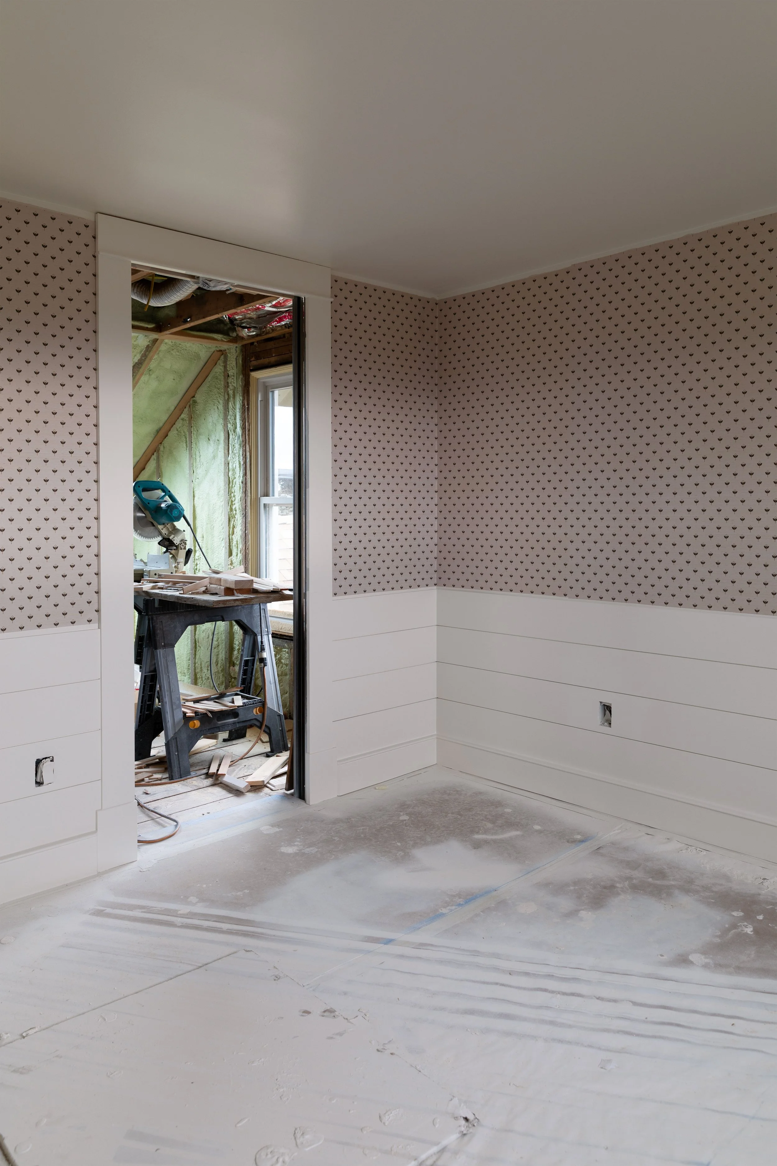 Finished grasscloth wallpaper in Daphne’s bedroom at the Hill House, showing small-scale floral print and look into future ensuite bathroom