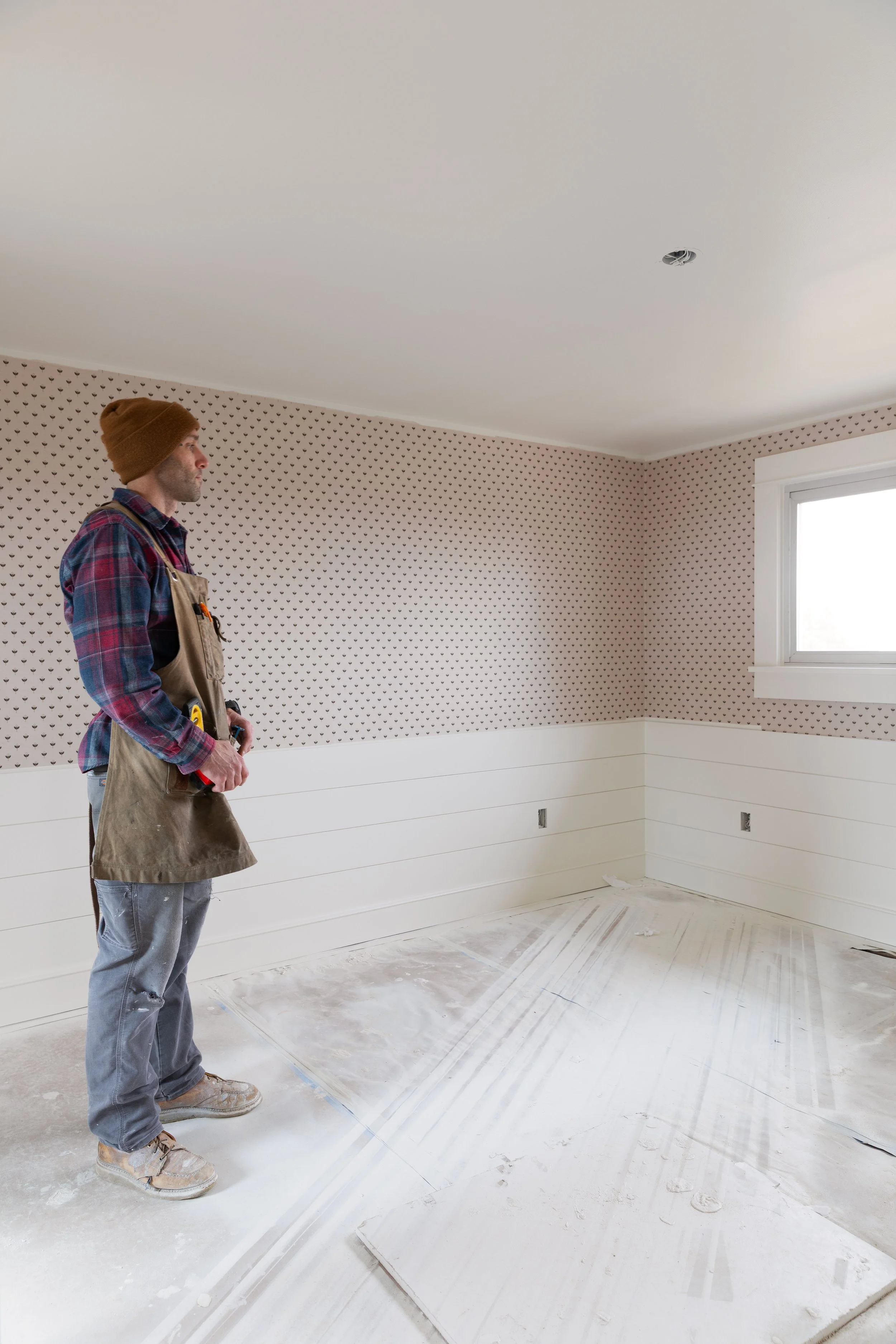 View from doorway into Daphne’s bedroom featuring newly installed grasscloth wallpaper
