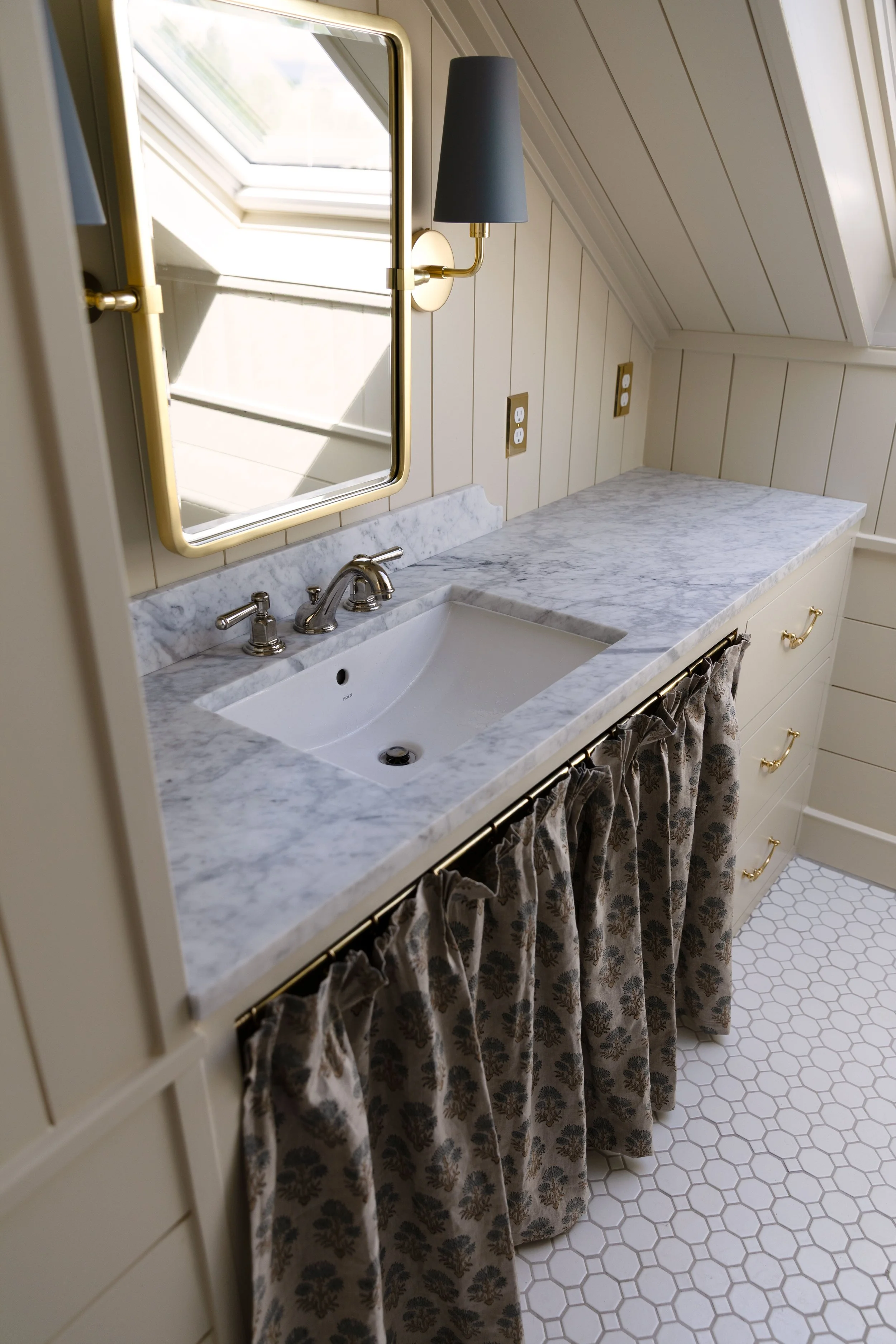 The Hill House hall bathroom with marble countertop and skirted front