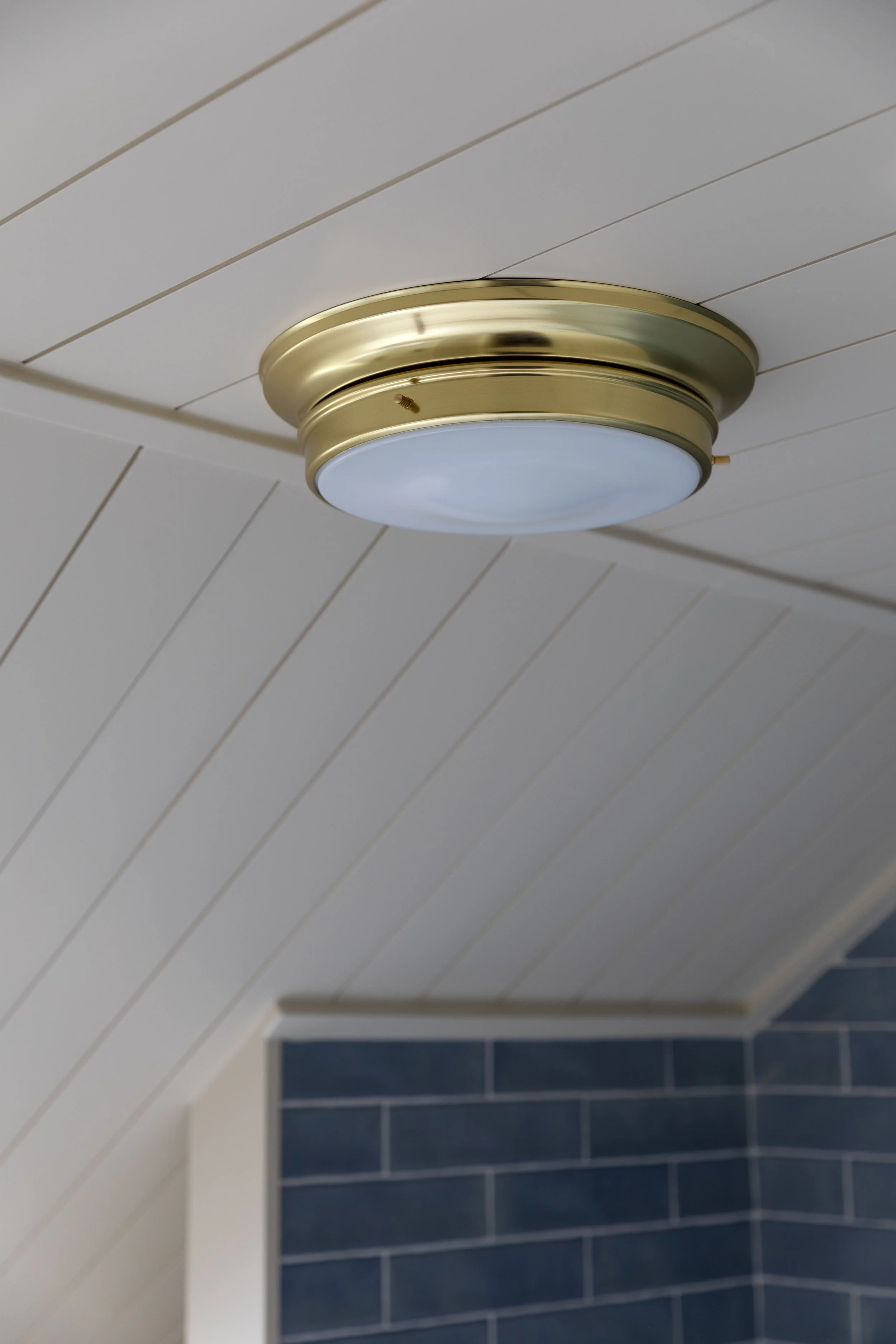 A brass flush mount light fixture for our 7' tall ceilings in the bathroom at the Hill House