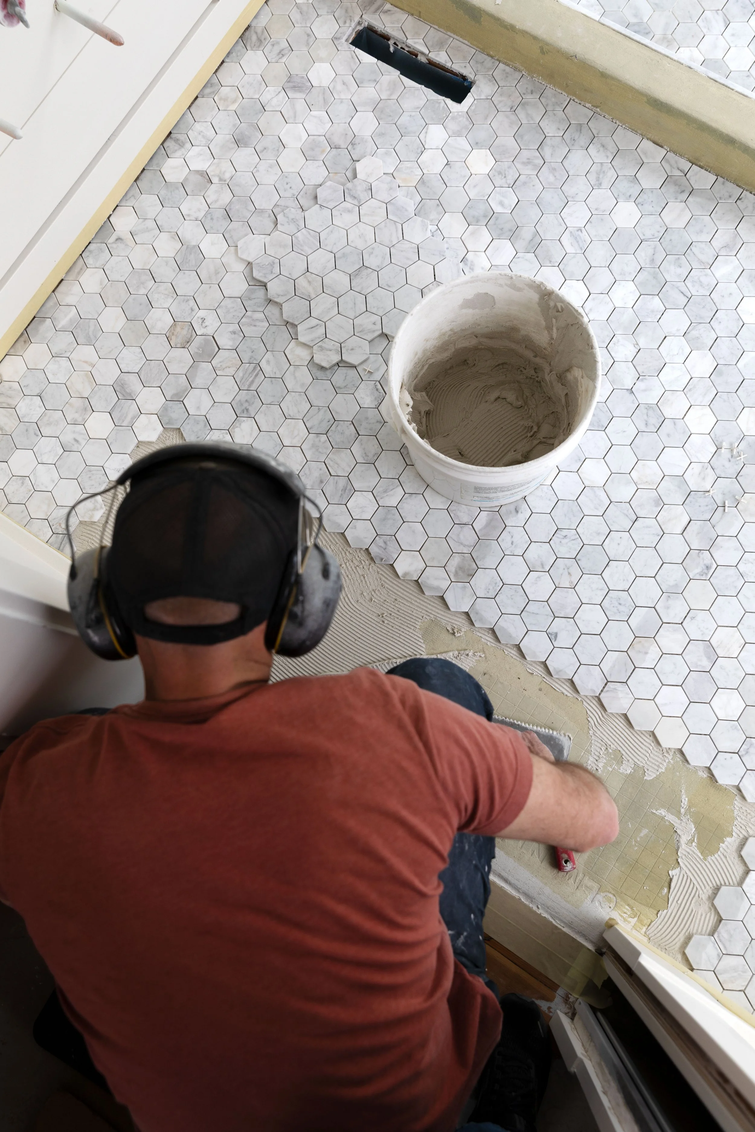 Laying marble hex tile in the ensuite bathroom floor