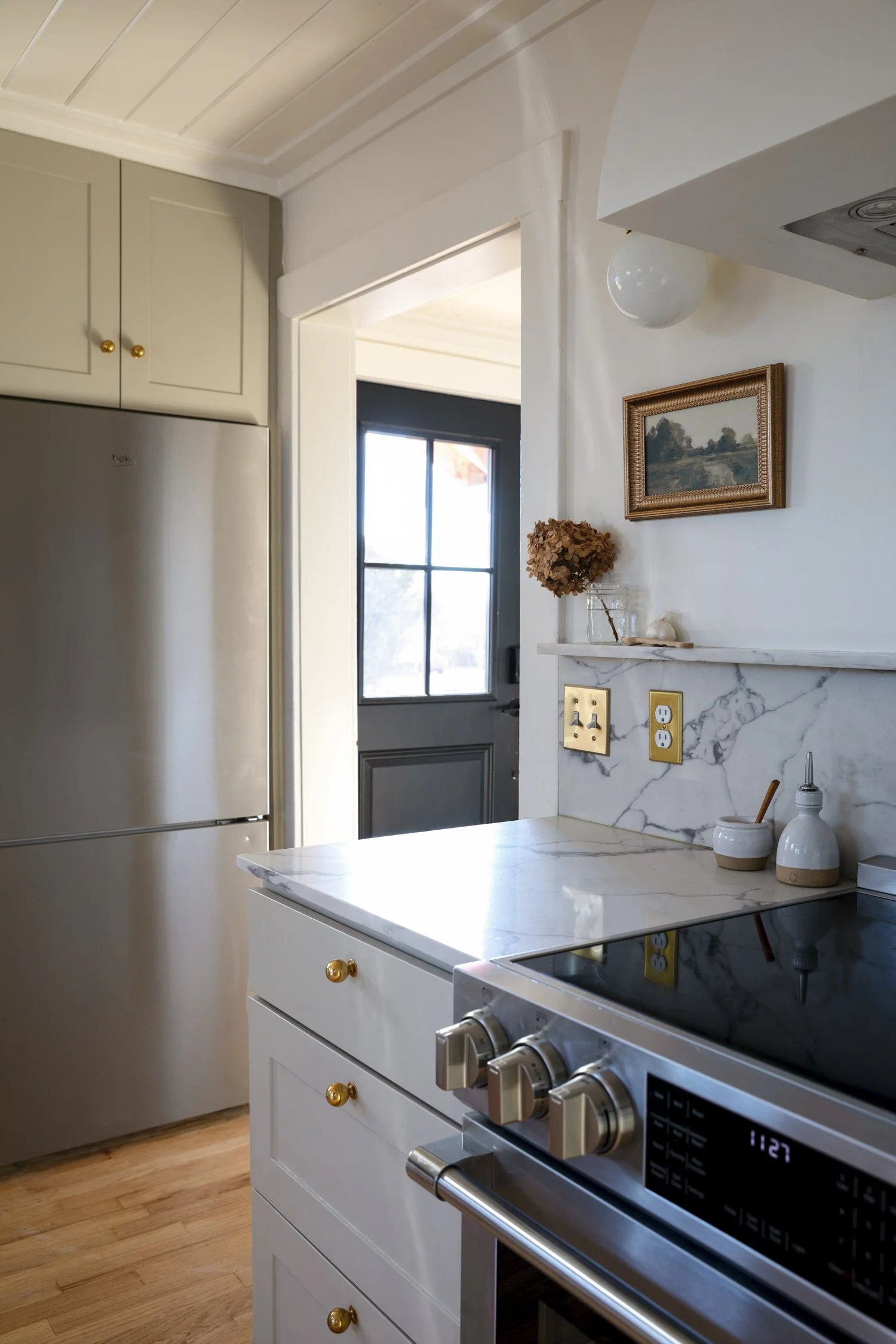 View from range toward fridge and front door showing small but efficient kitchen layout.