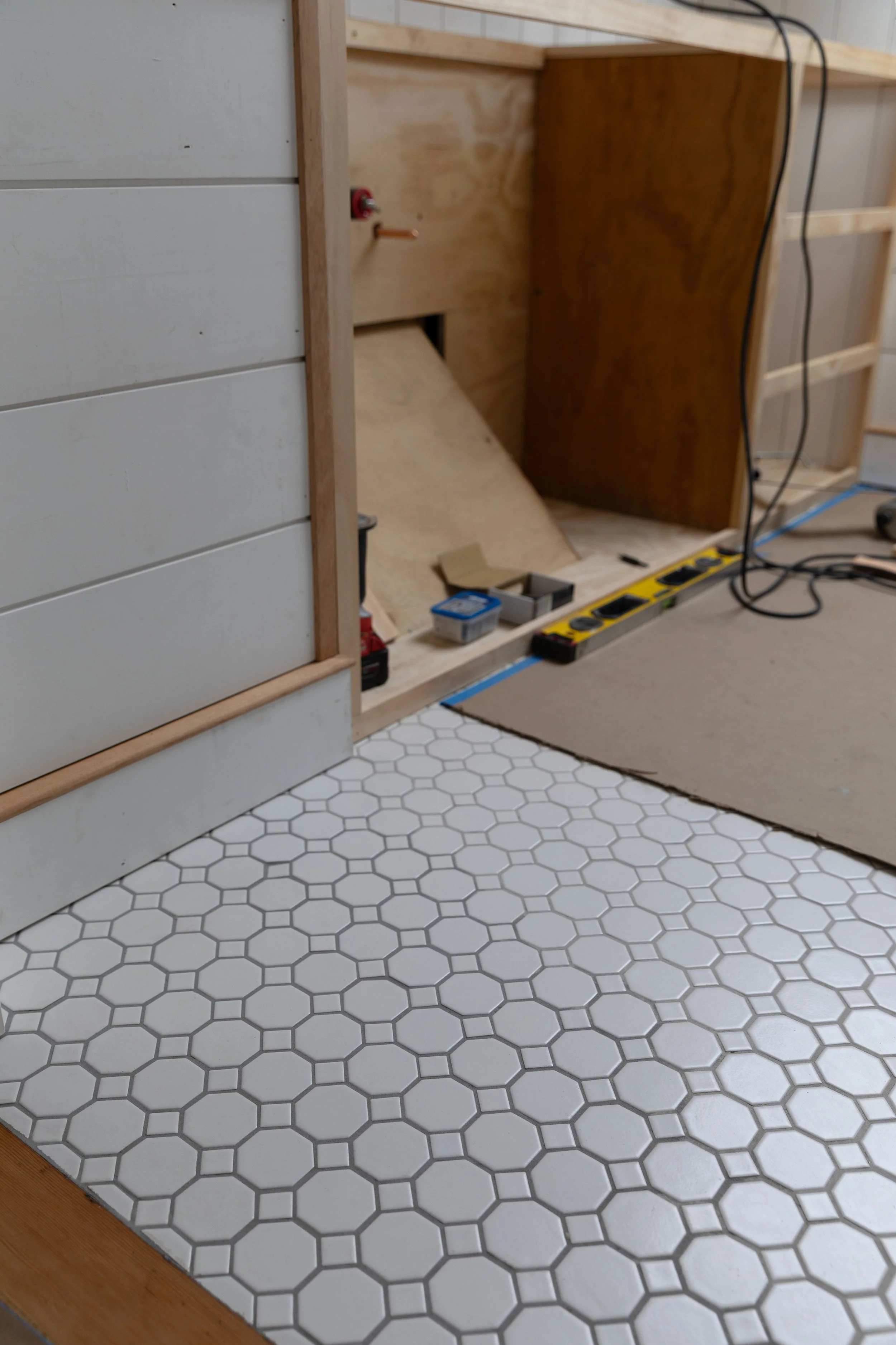 Bathroom tile floor showing epoxy grout color variation where two grout batches meet
