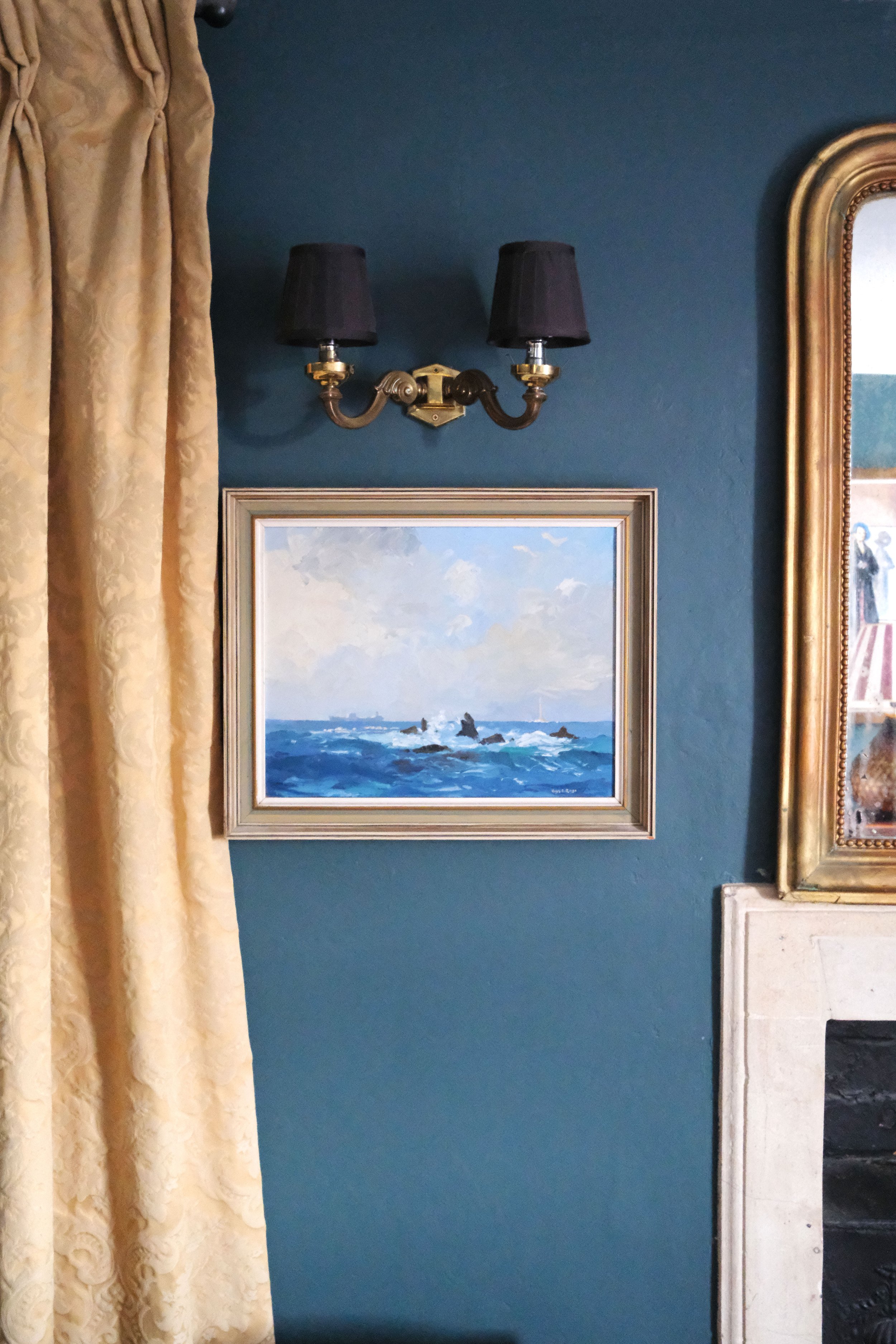 Twin bedroom with colorful bedding, old paintings, and dark wood furniture in Bath