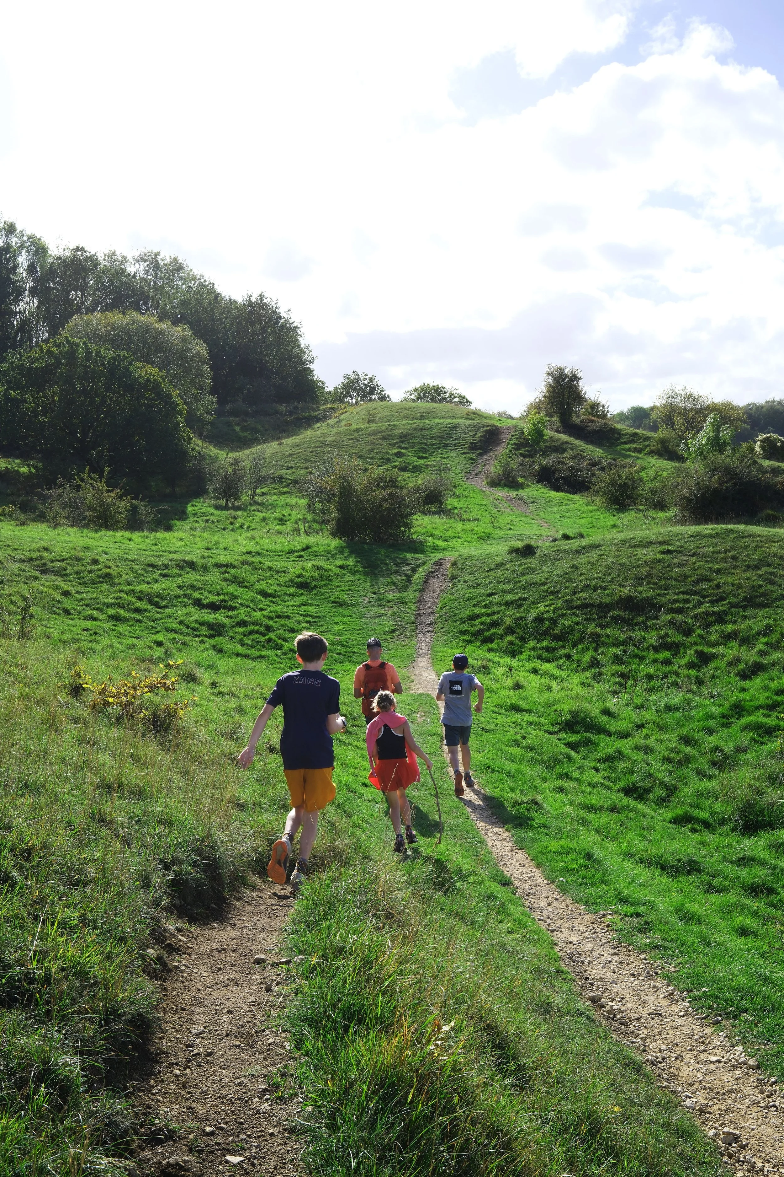 Family hiking the Cotswold Way through the English countryside