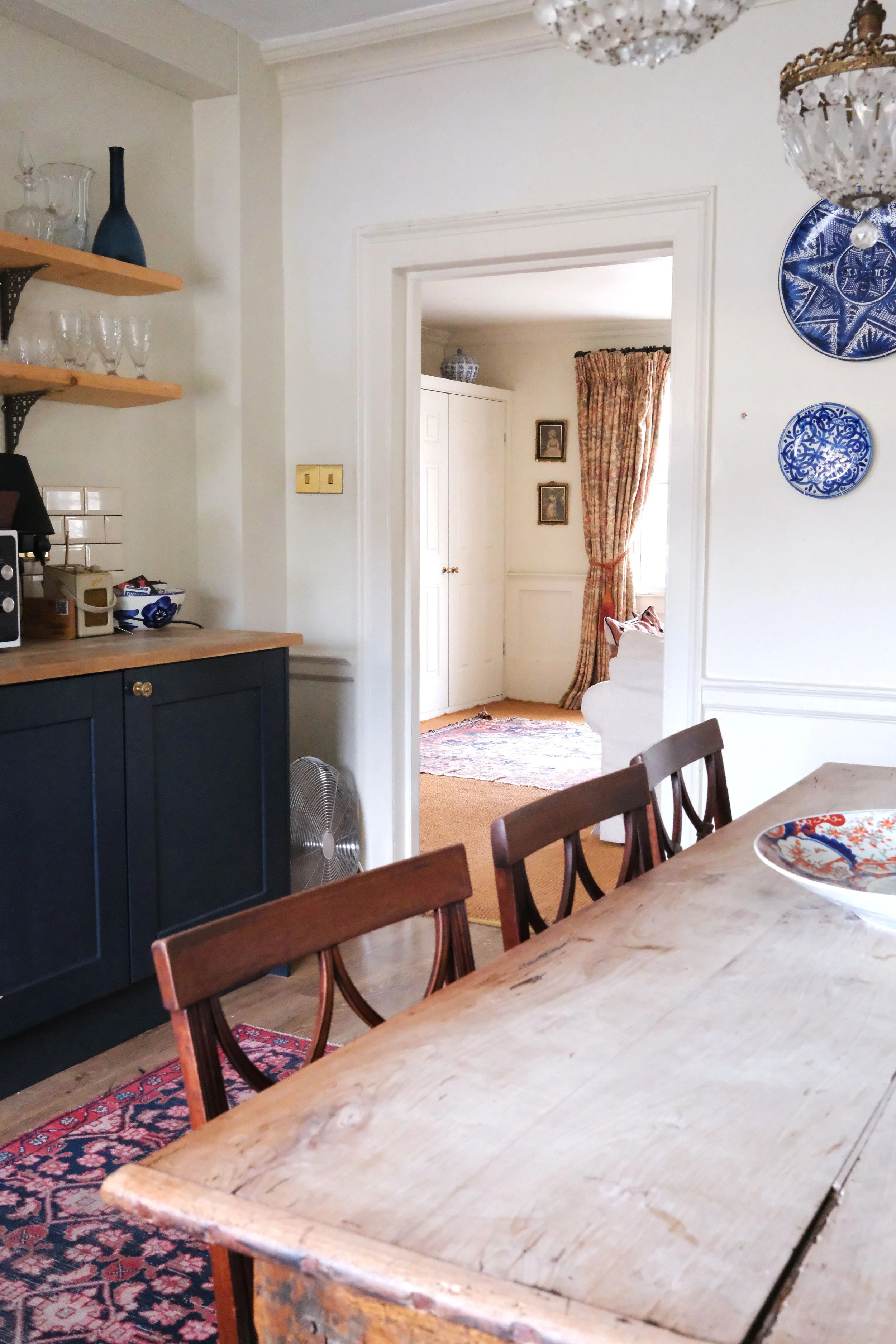 Character-filled Bath apartment kitchen with dark cabinetry, wood counters, and open shelving