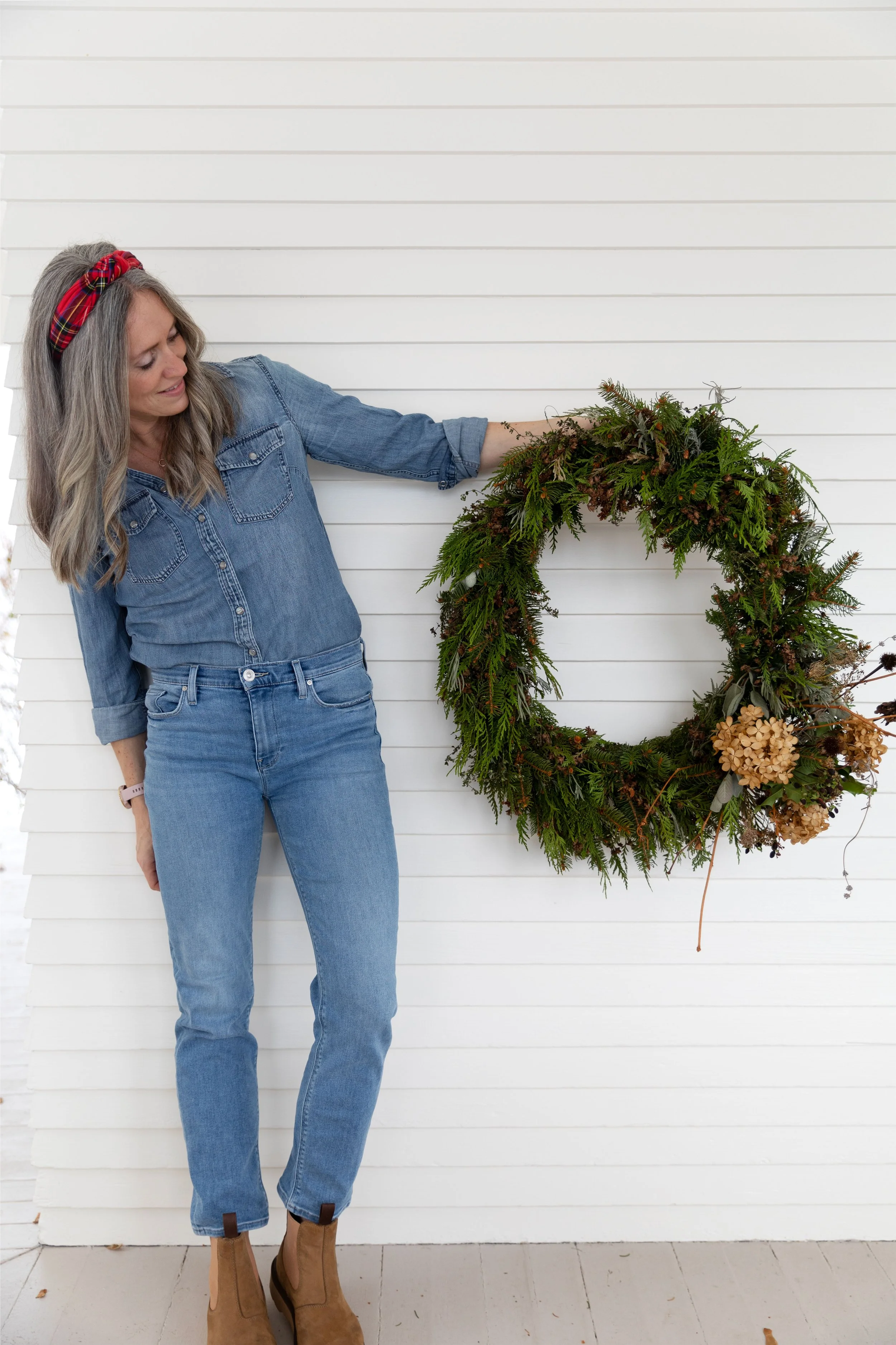 White Farmhouse exterior with handmade wreath — welcoming old-house Christmas curb appeal.