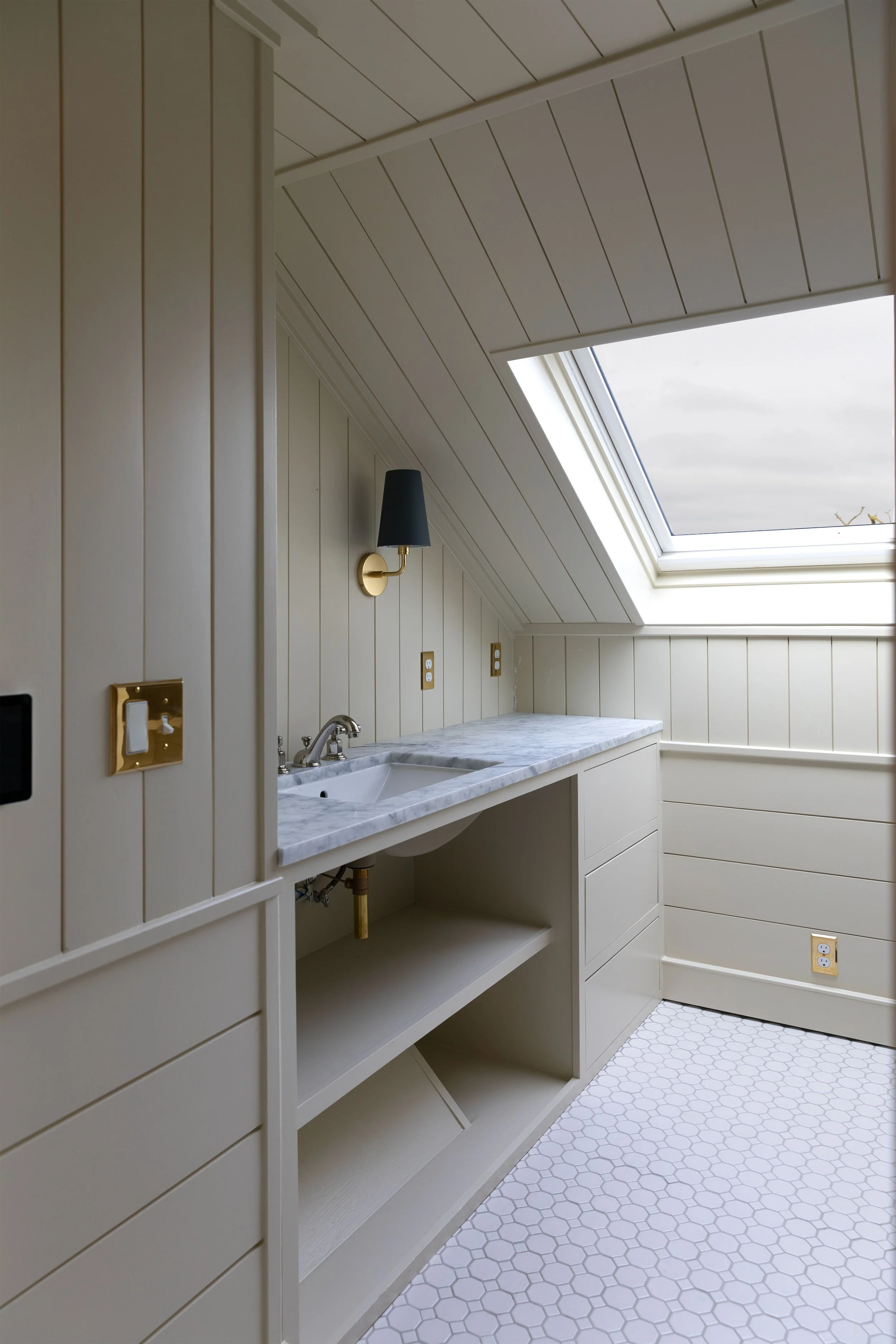 Awkward bathroom vanity layout in our Hill House hall bath showing the sloped floor and narrow walkway before adding a cabinet skirt