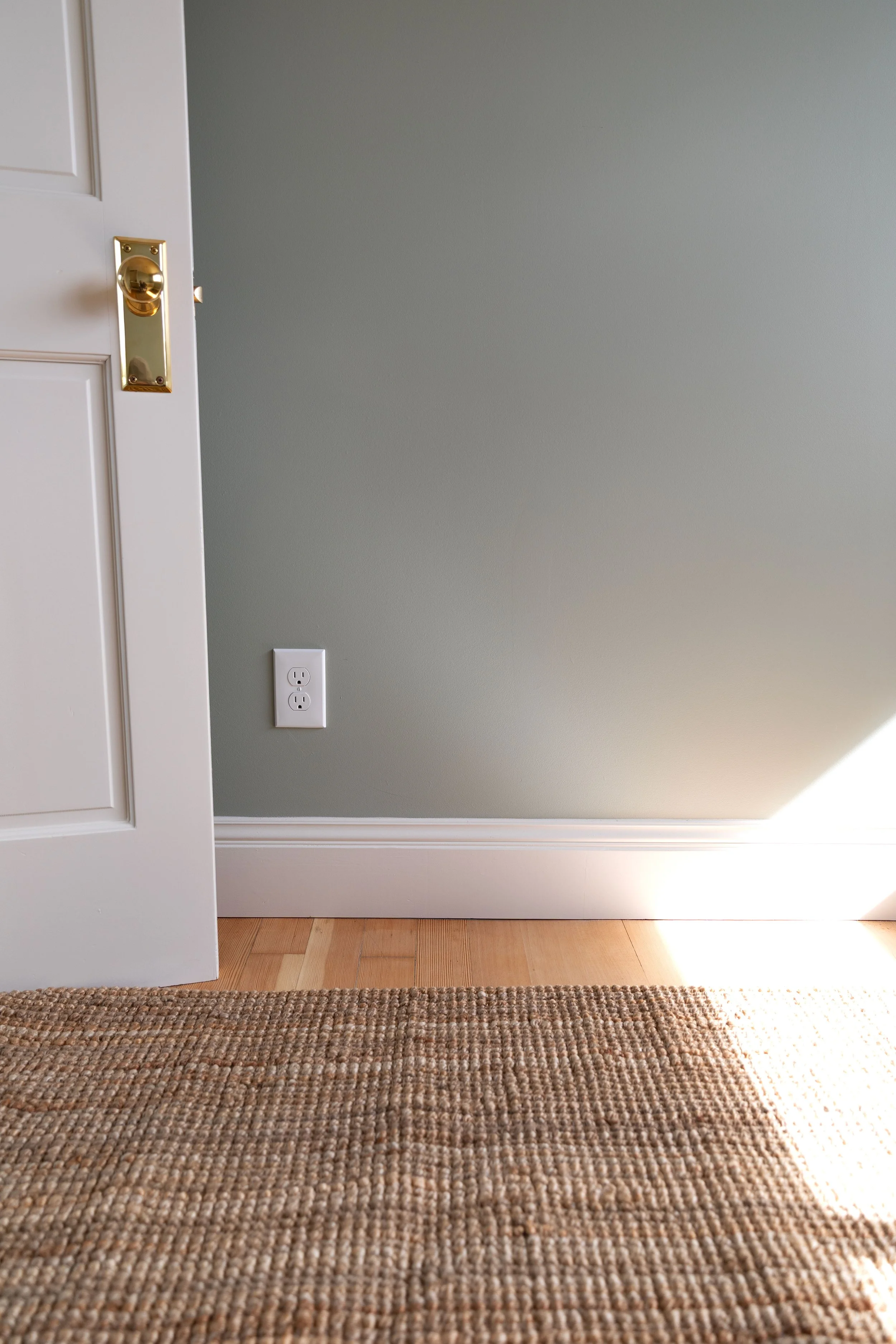 Hill House base detail in blue gray bedroom with fir floors and jute rug