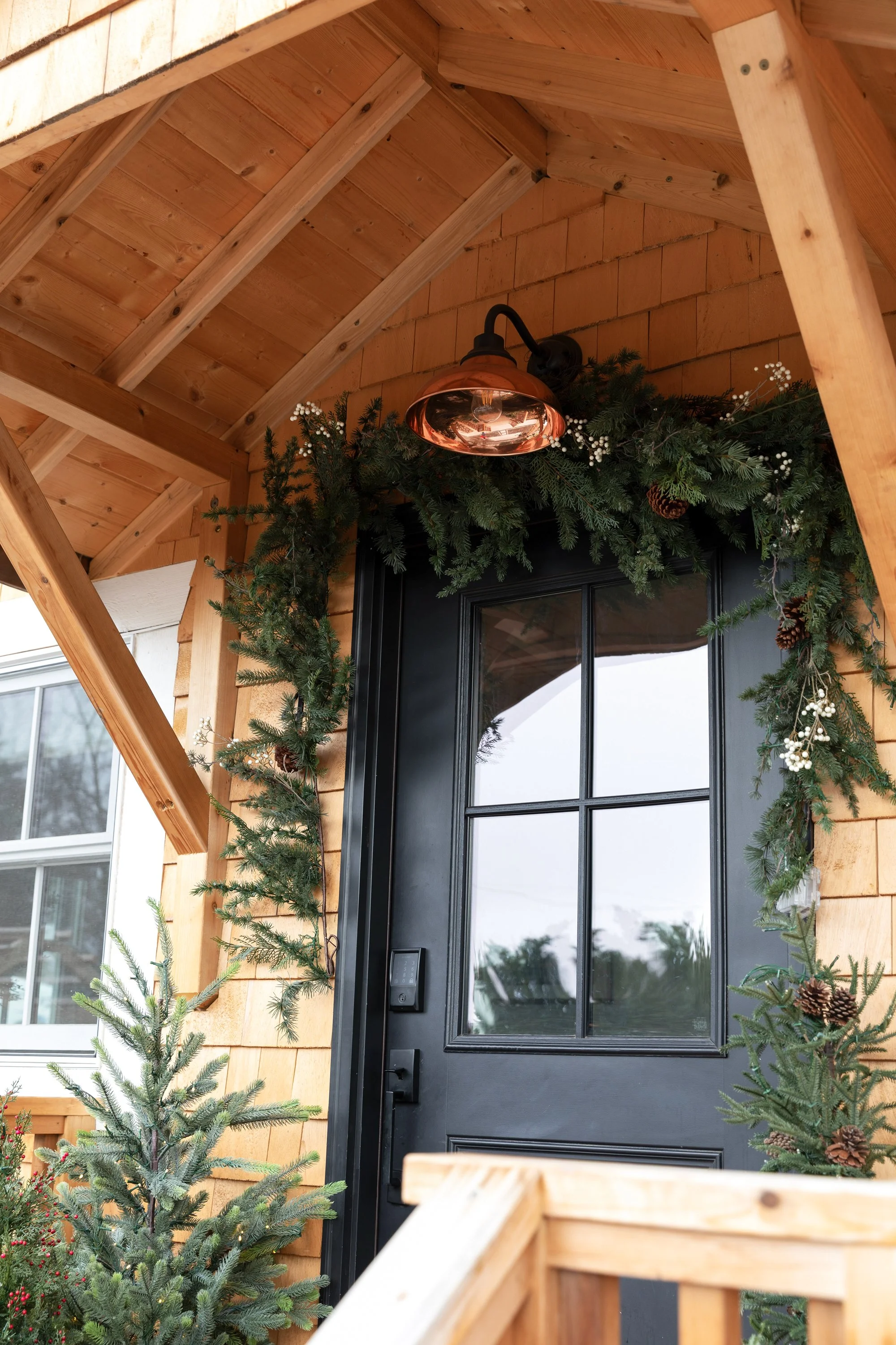 Copper sconce with holiday garland above the Poplar Cottage front door