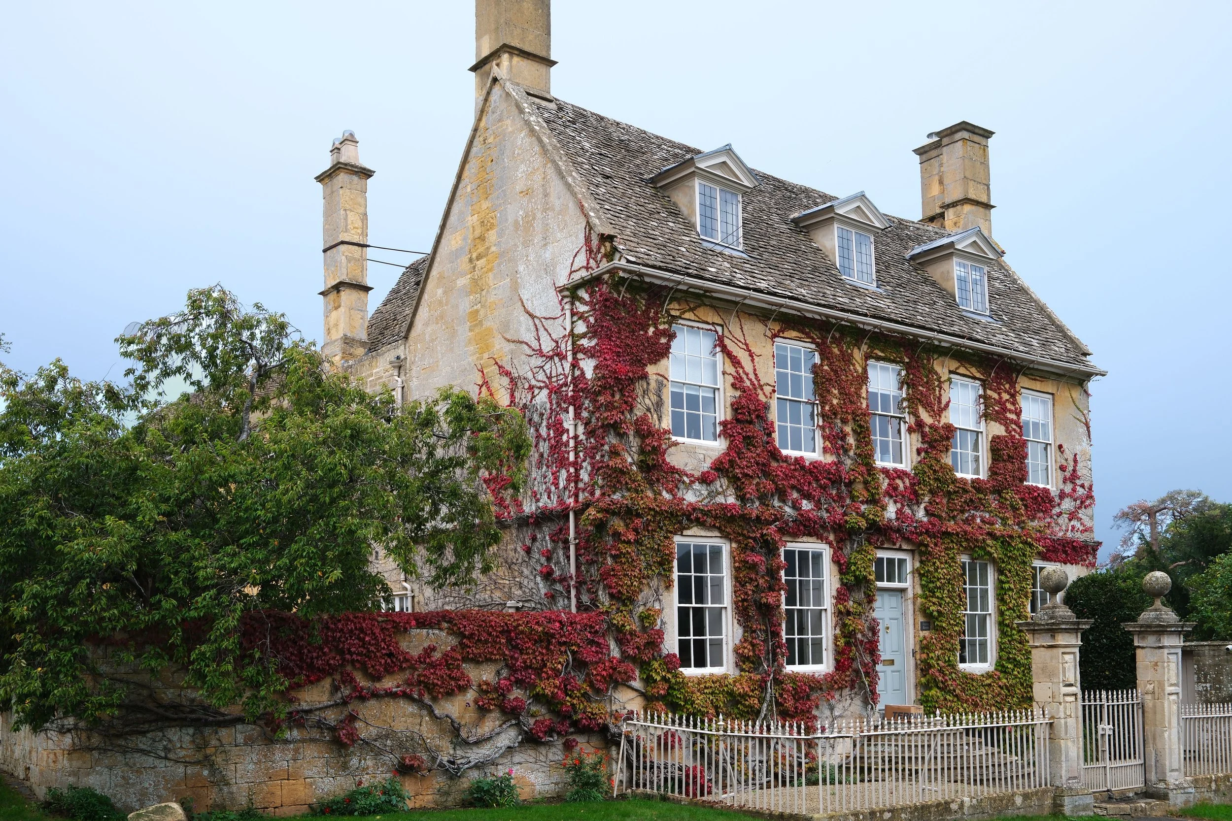 a honey-colored stone building along the street in Broadway, England