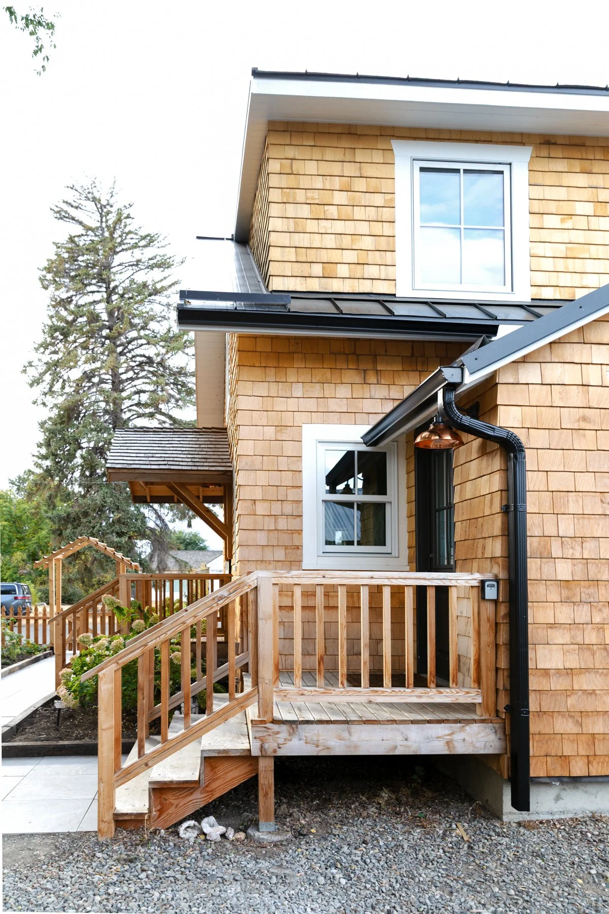 Poplar Cottage exterior with black metal roof and new gutters — classic meets modern design