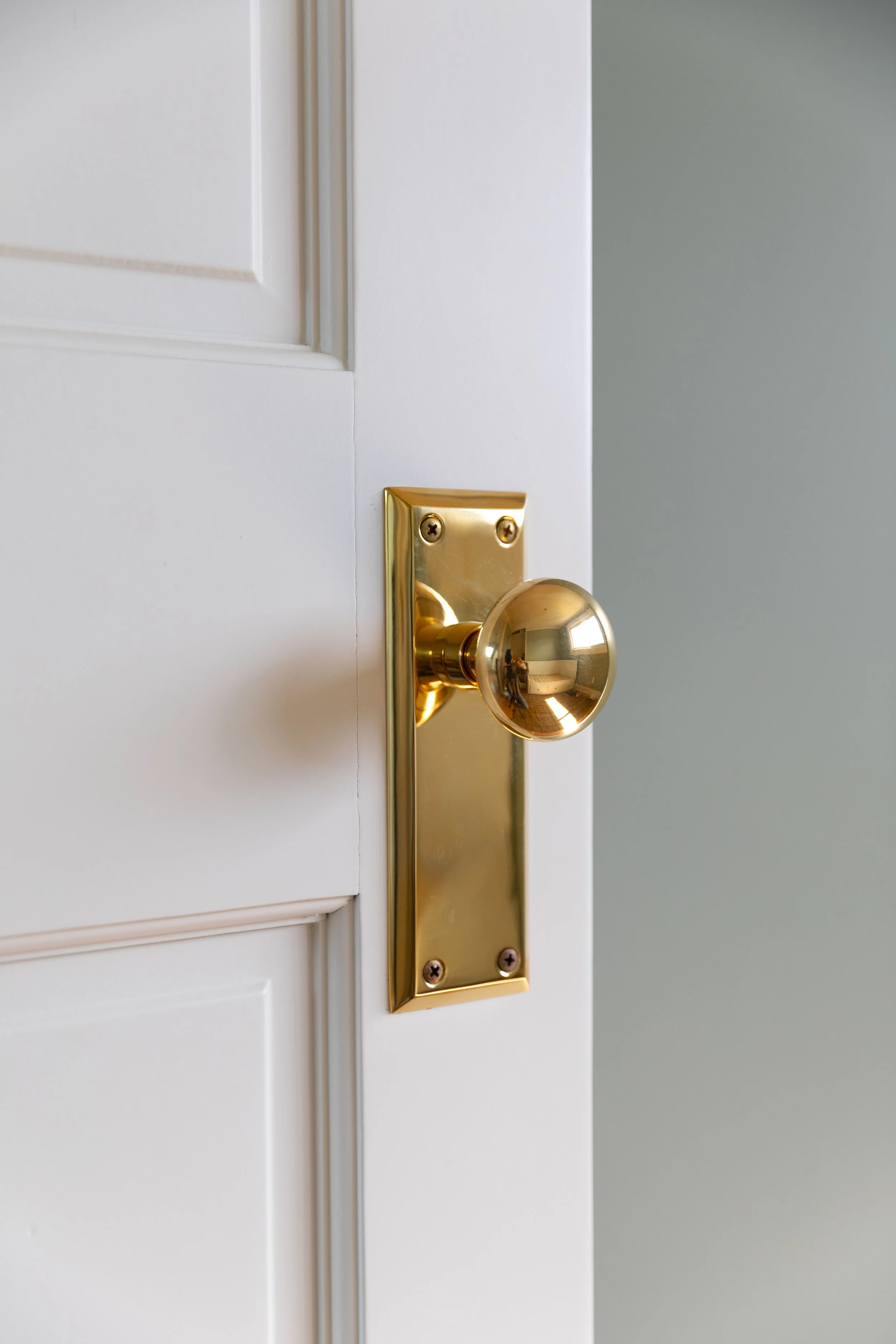Unlaquered brass doorknob with door painted in Farrow and Ball slipper satin