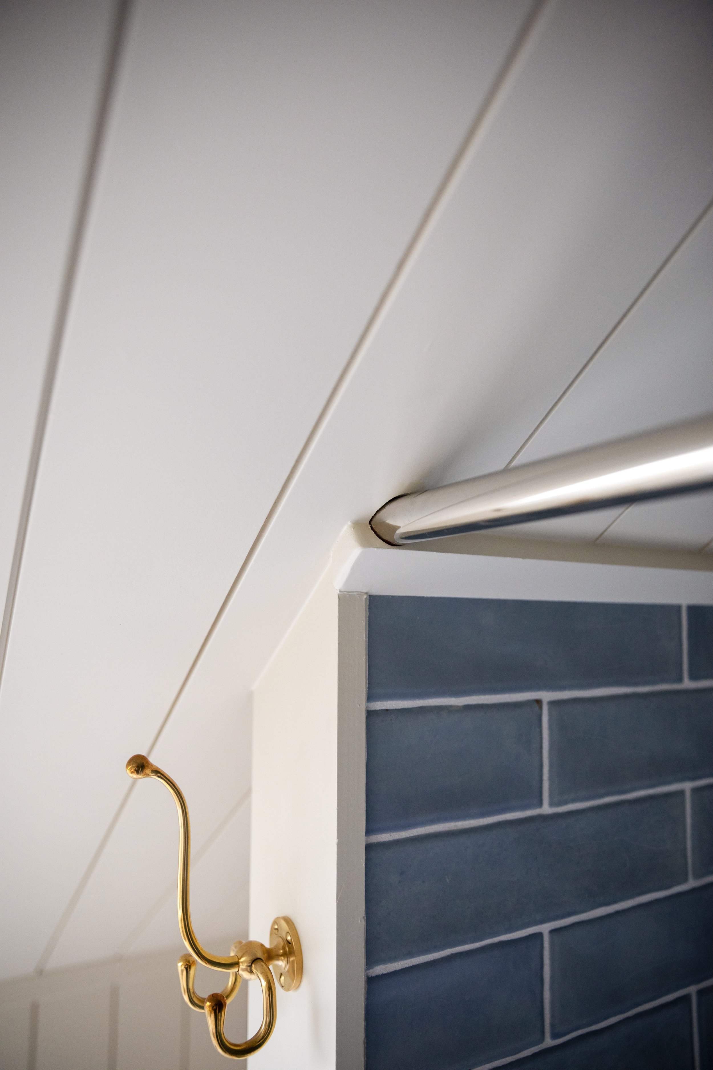 Shower curtain rod termination into molding at a sloped attic ceiling