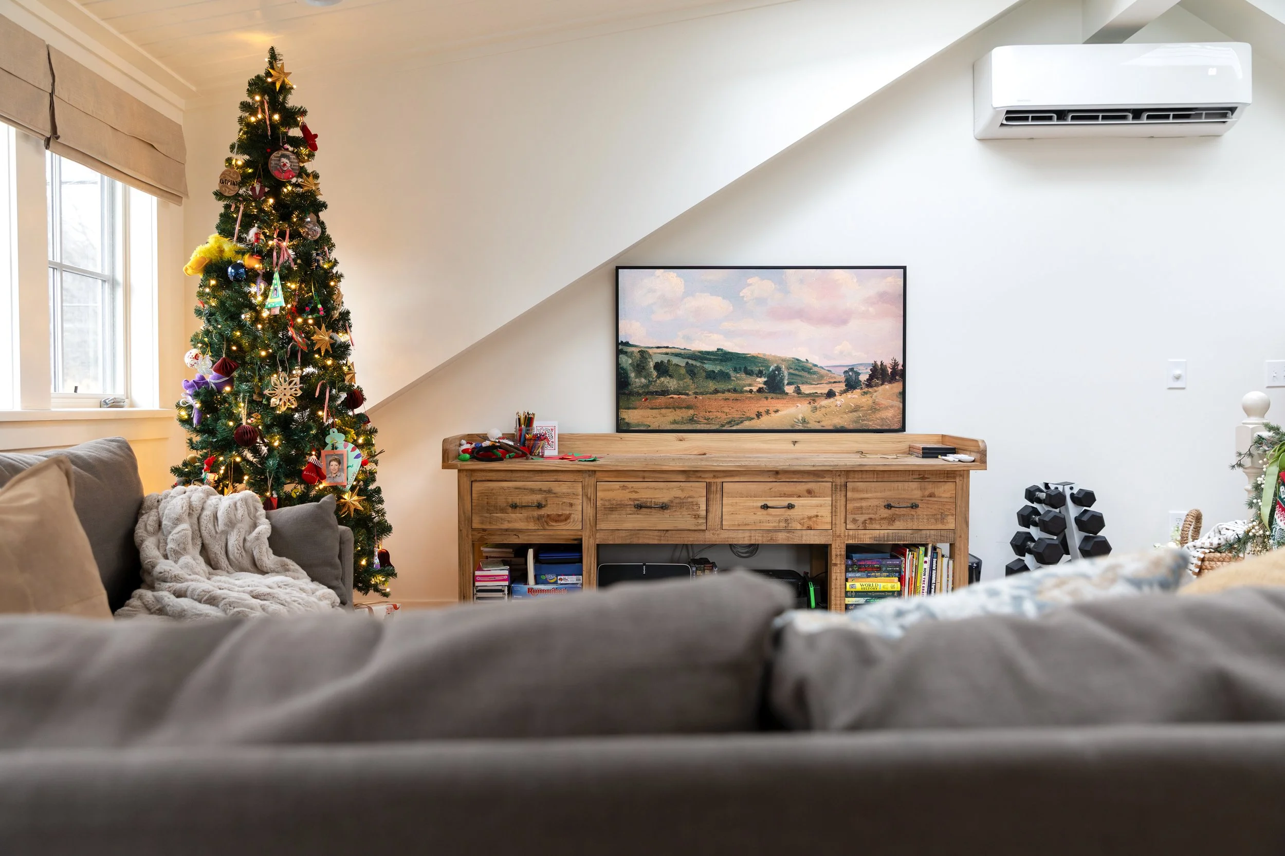 Holiday living room with Frame TV displaying vintage art and a skinny Christmas tree