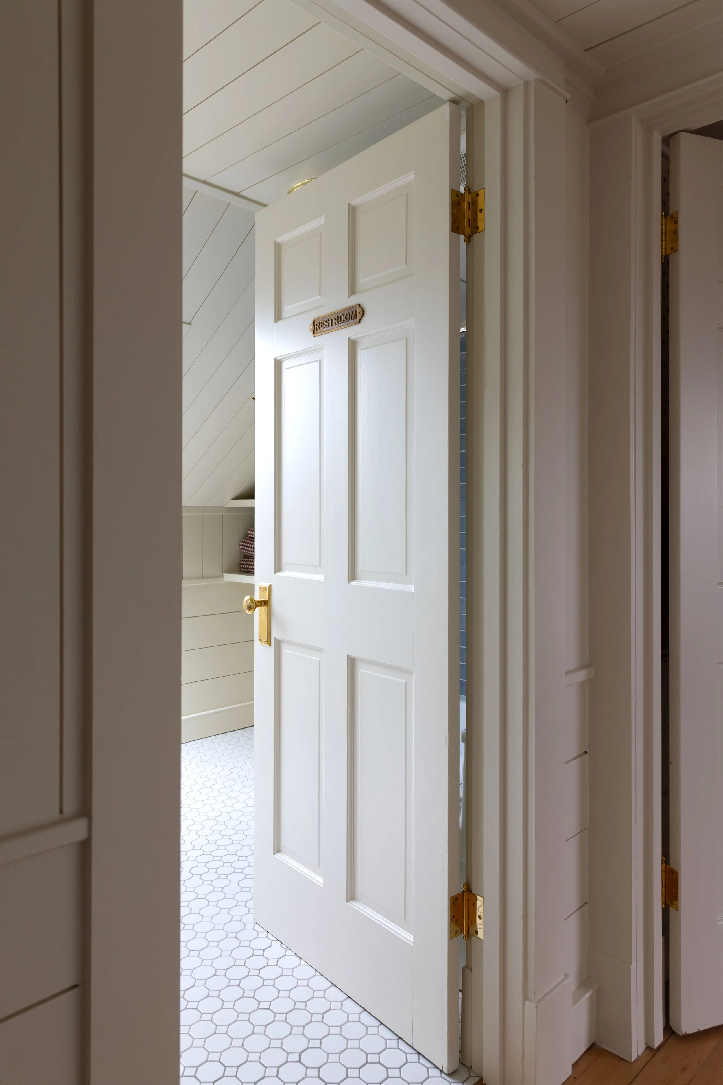 Unlacquered brass bathroom doorknob with several years of natural patina and darkened wear