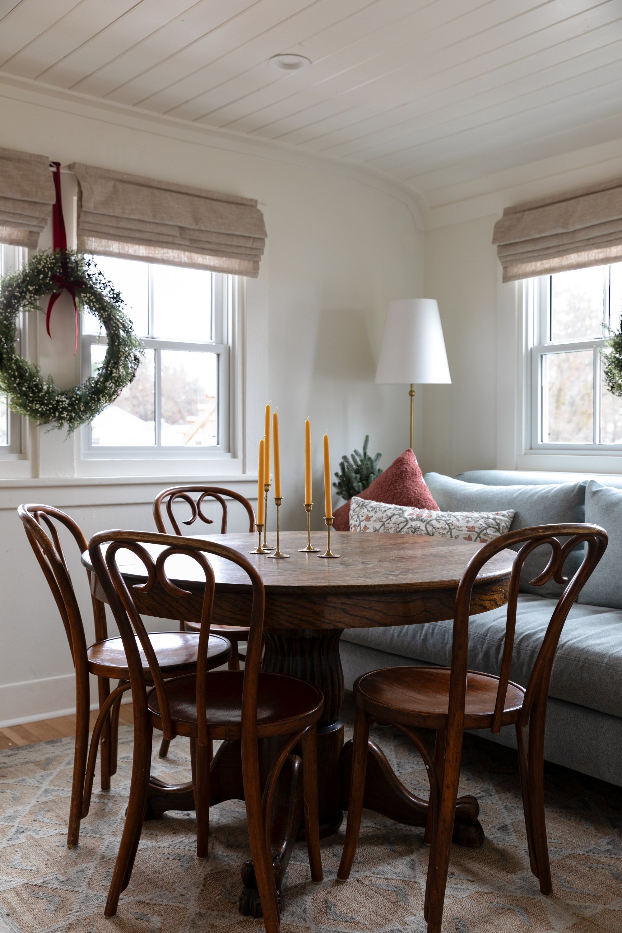 Cozy holiday dining room with blue sofa, antique table, and candles at the Poplar Cottage