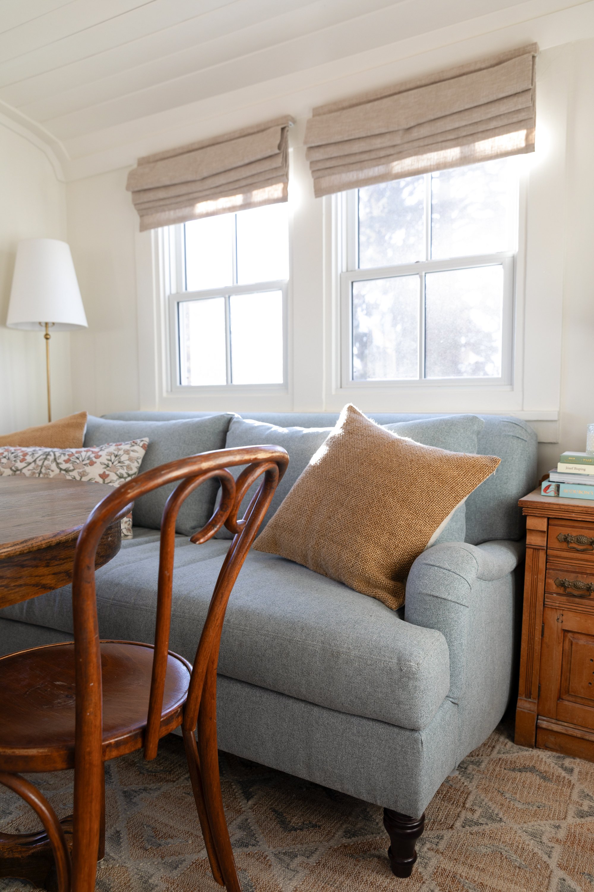 Close-up of blue sofa with rolled arm and woven pillow in the Poplar Cottage sitting room