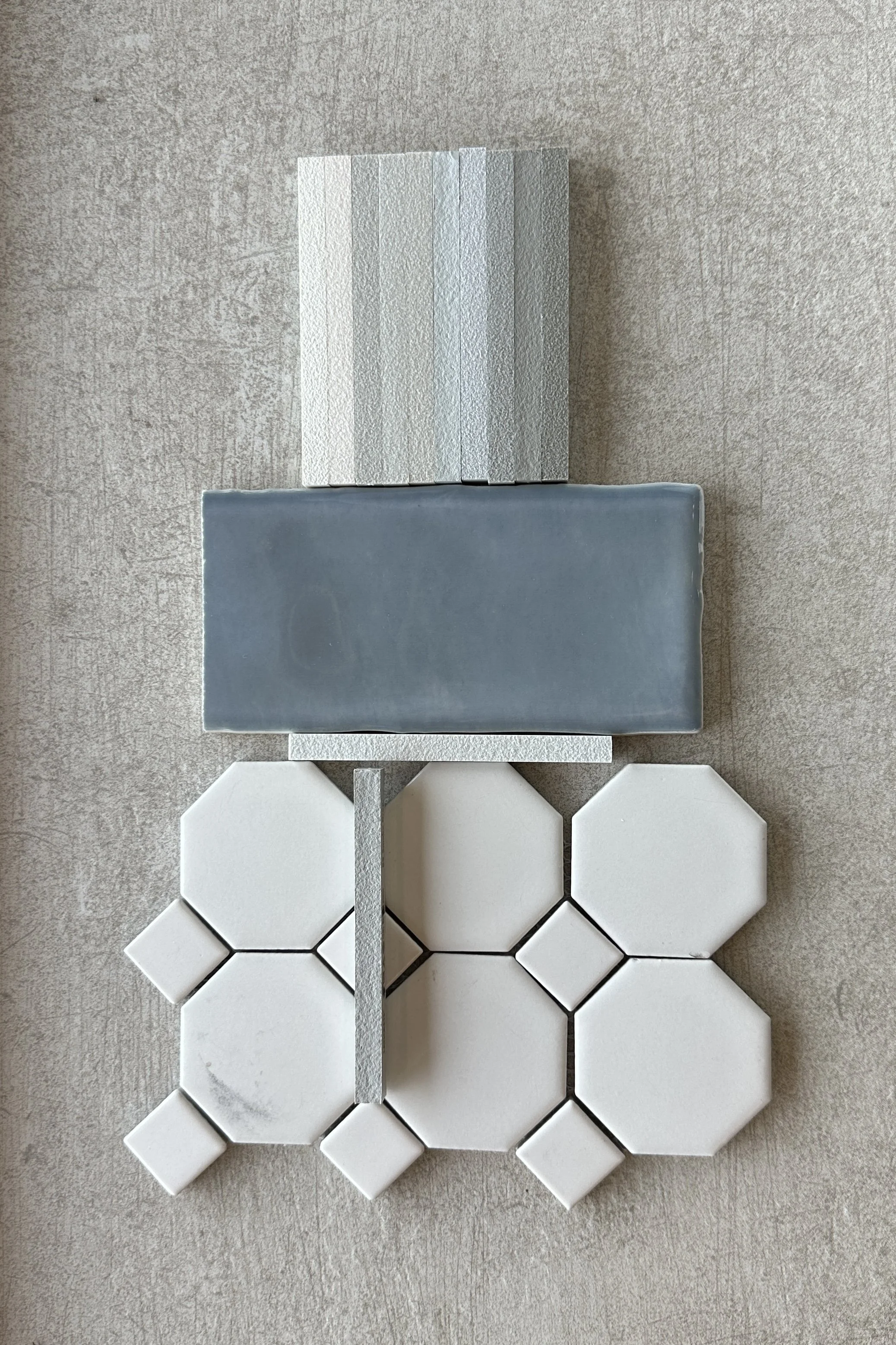 Flat lay of bathroom tile and epoxy grout color samples before installation