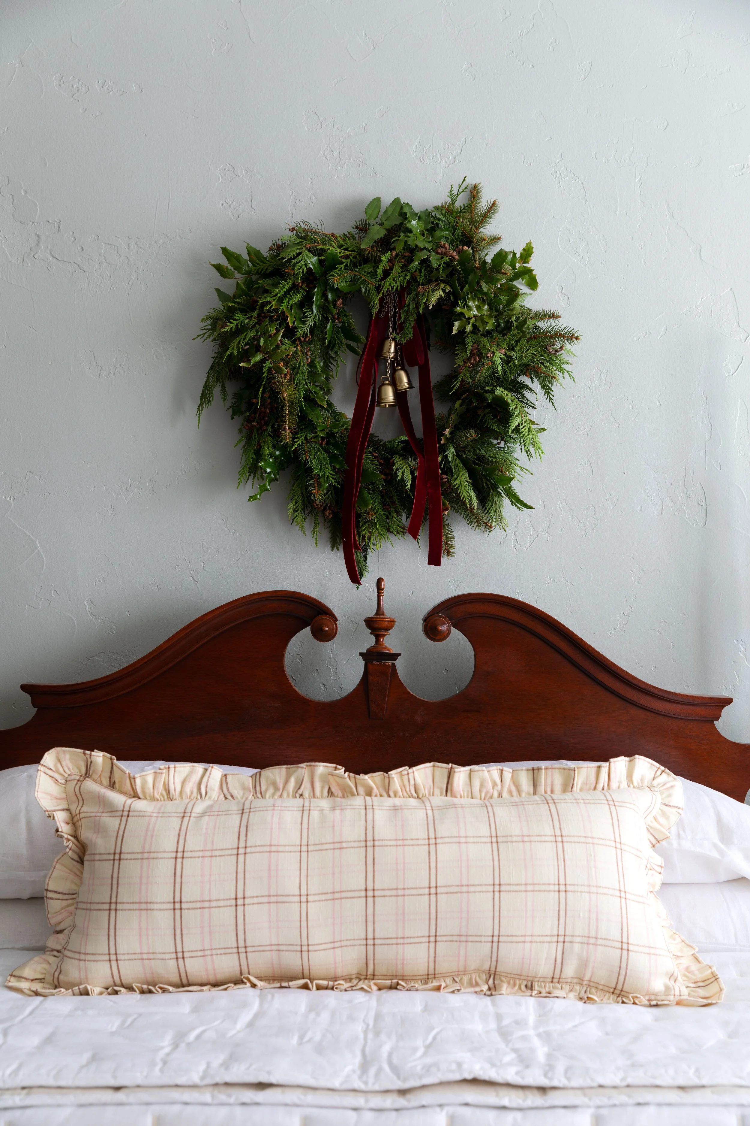 Farmhouse bedroom with handmade wreath with brass bells