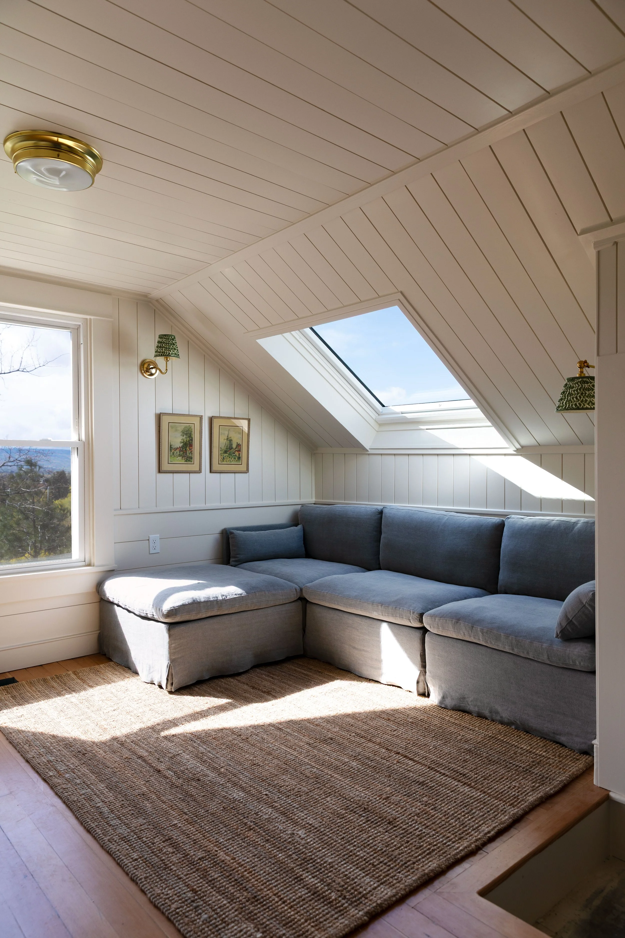 Cozy upstairs snug with skylight, window, and soft neutral finishes in our 1910 Hill House