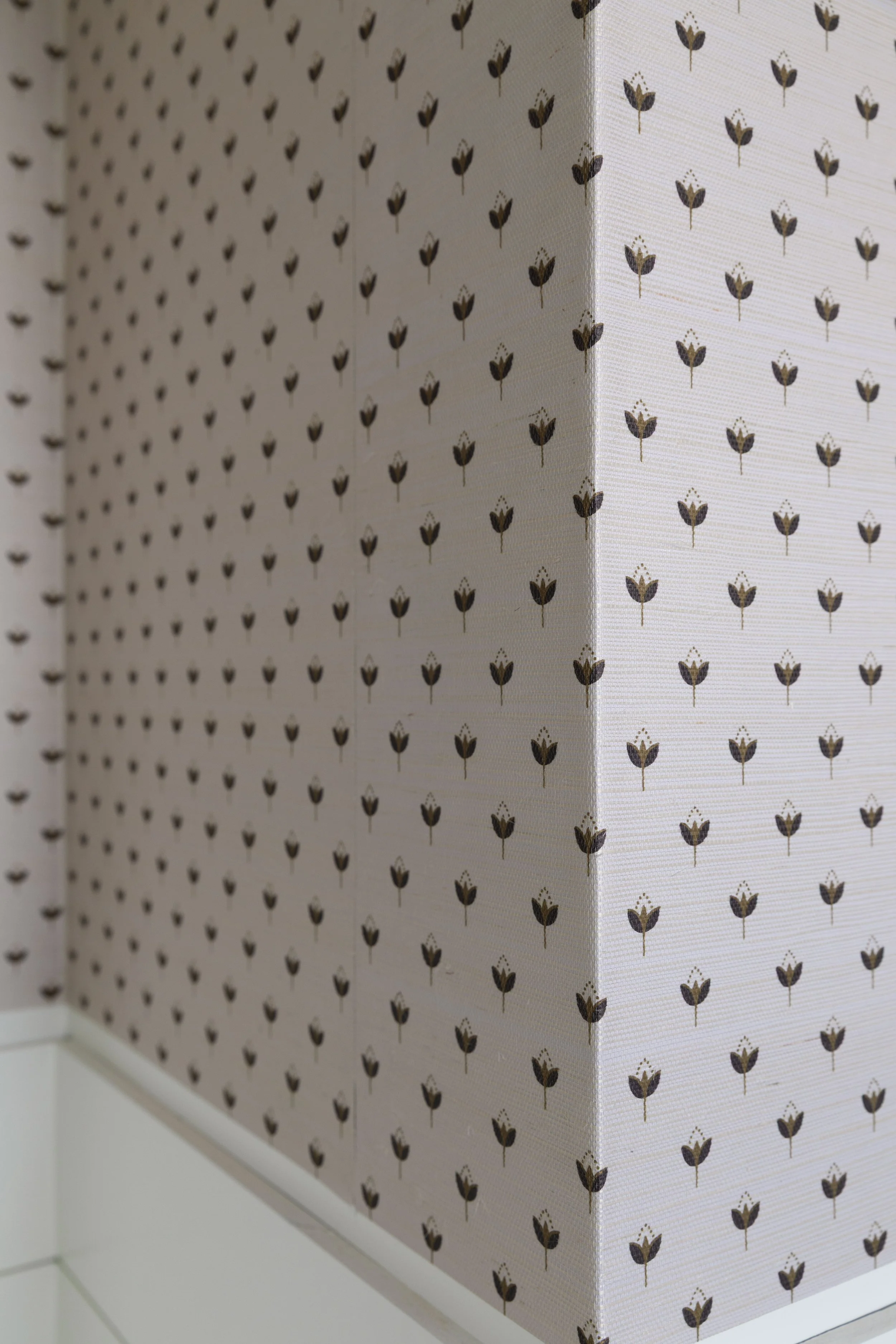 Detail of grasscloth wallpaper wrapped and trimmed at an outside corner