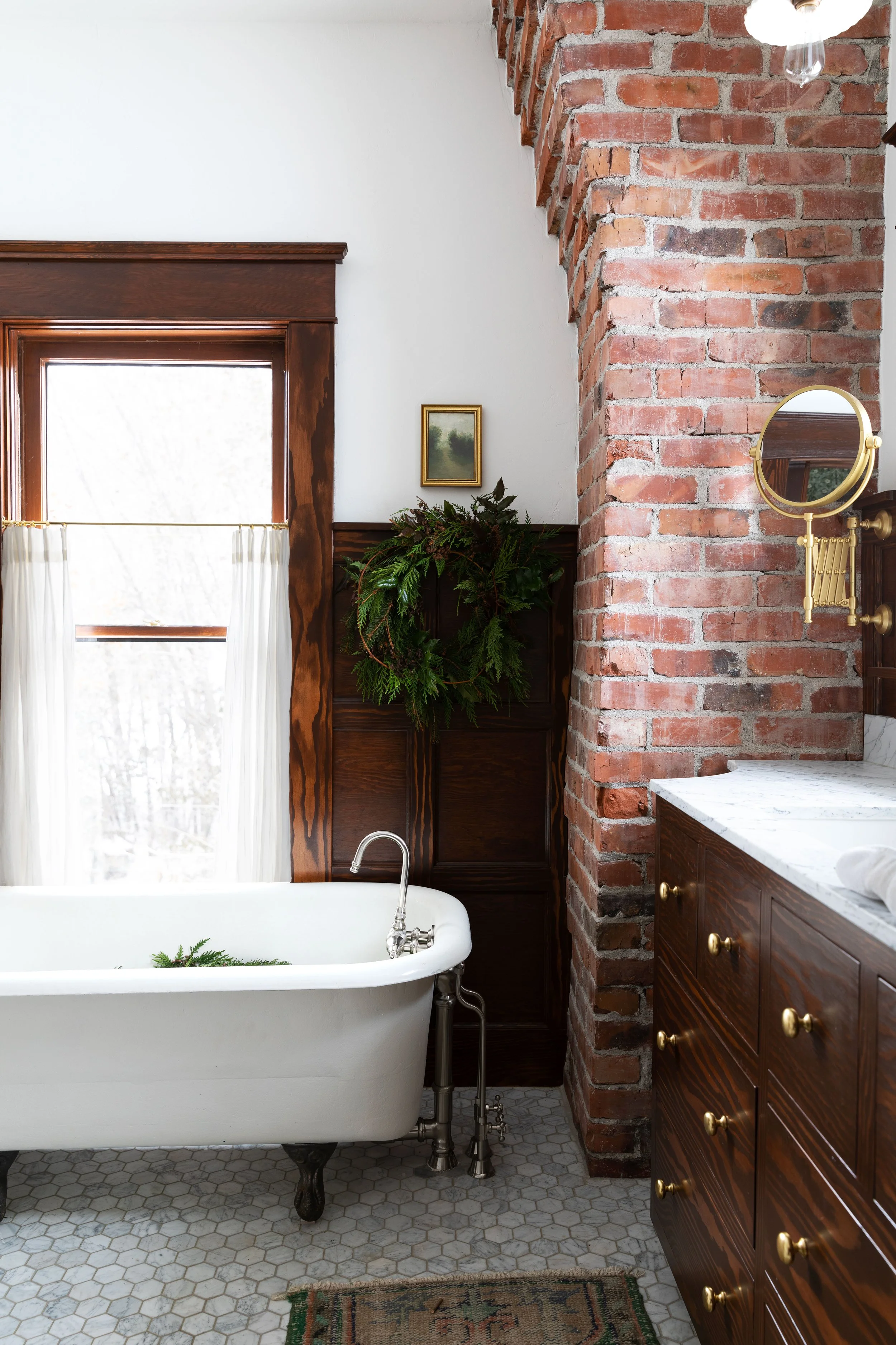 Cozy farmhouse bathroom decorated for Christmas with a simple wreath — timeless holiday decor inspiration.