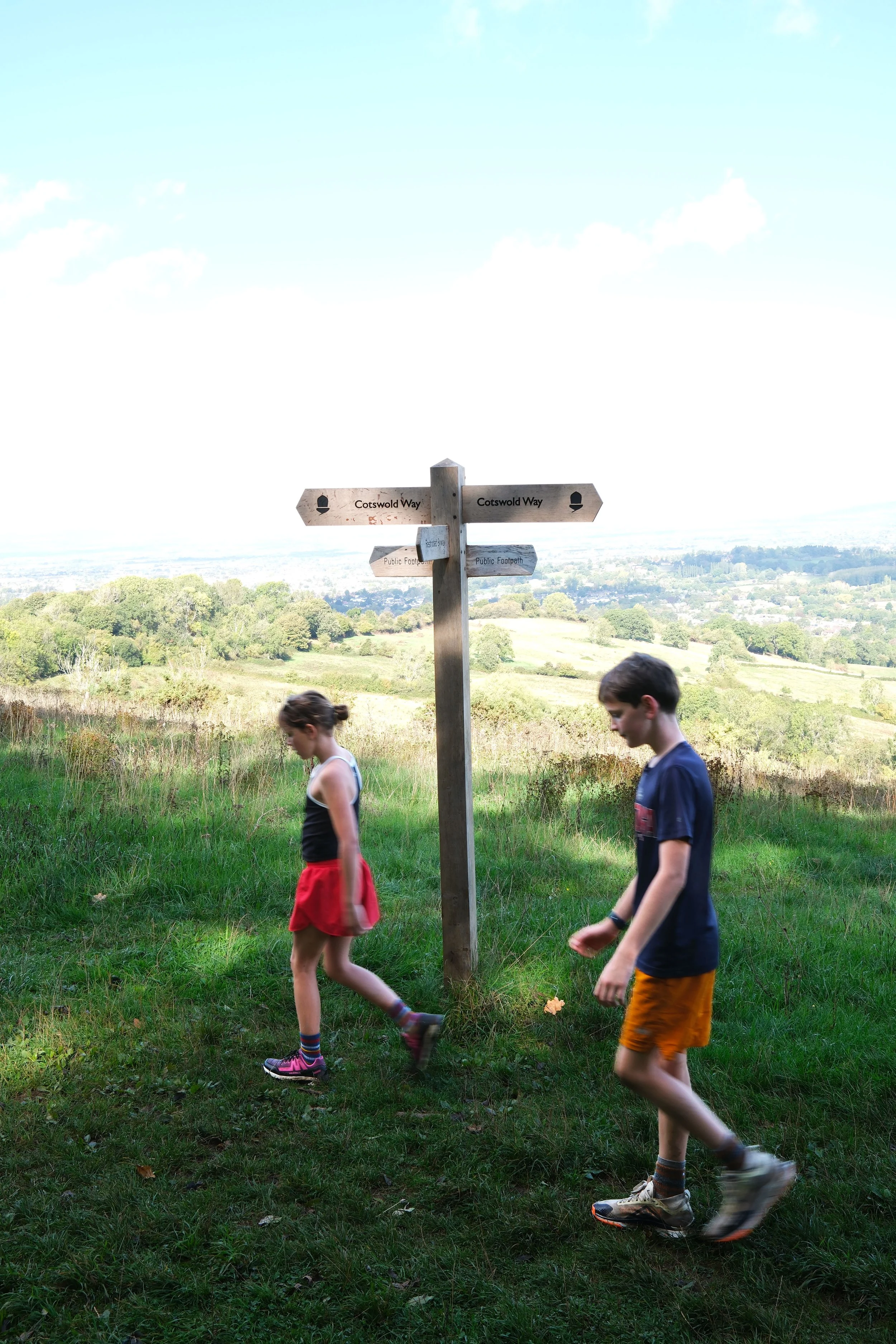 Family hiking the Cotswold Way through the English countryside