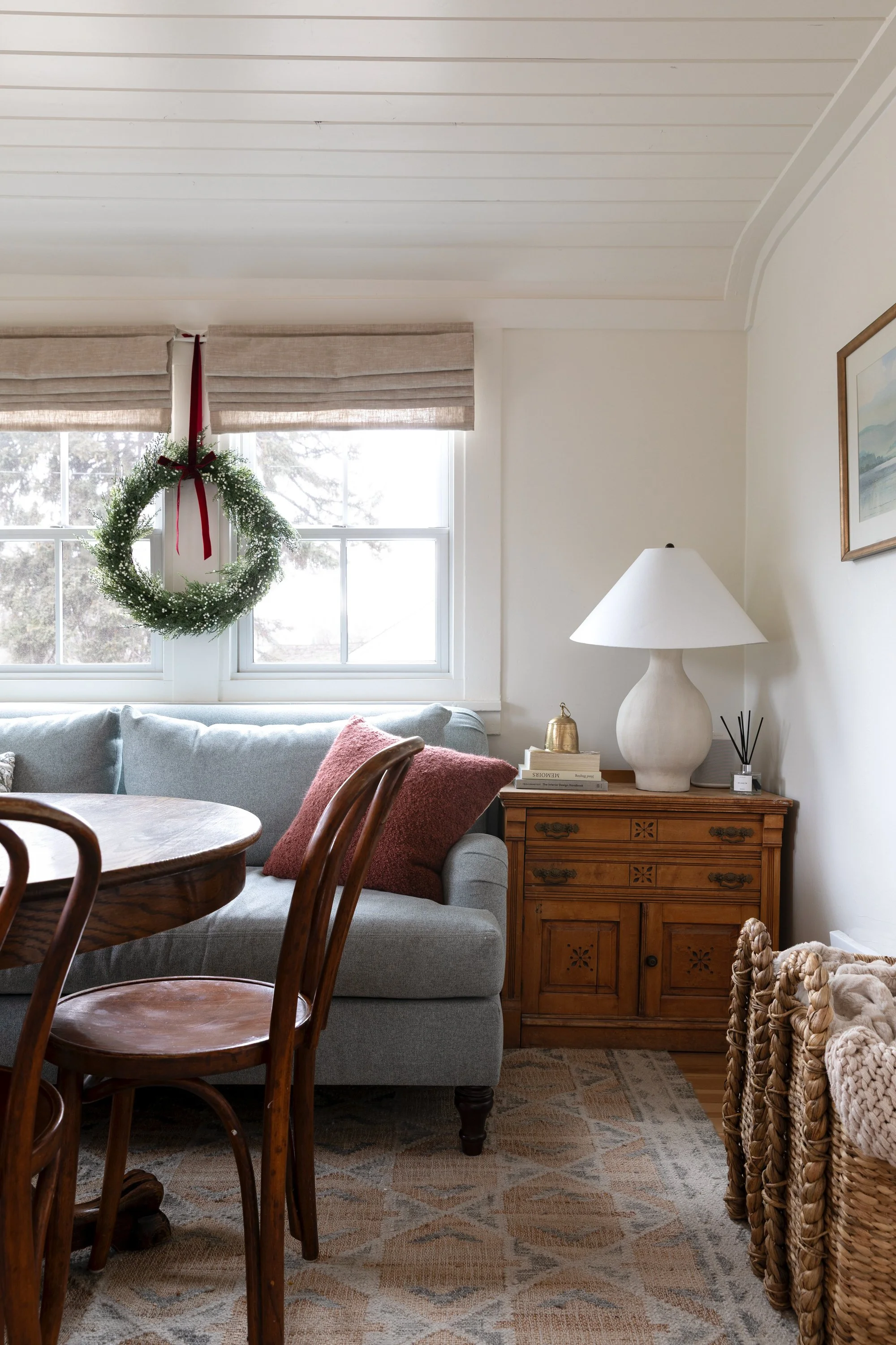 Holiday dining room with antique furniture, blue sofa, and warm lighting at the Poplar Cottage
