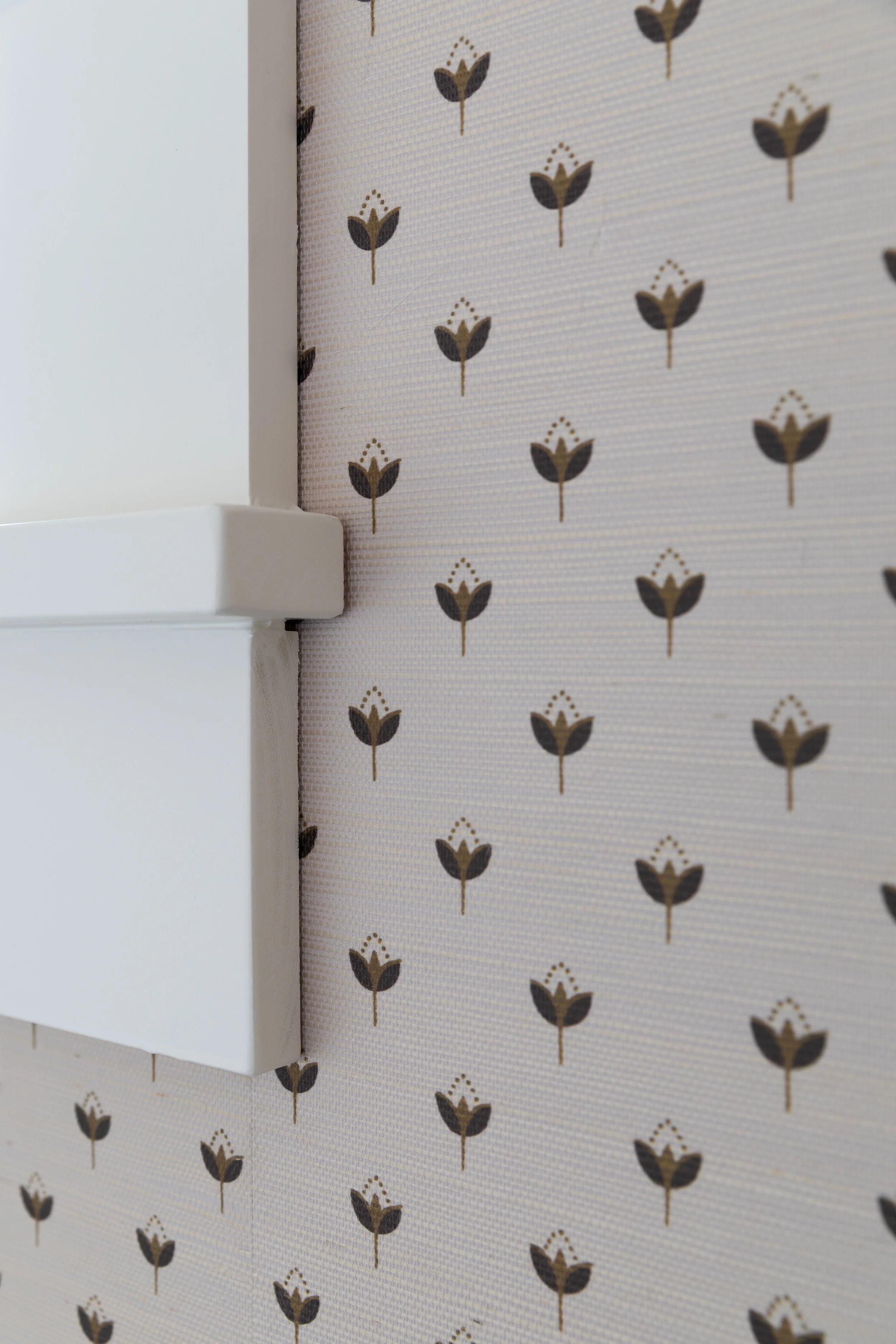 Installing grasscloth wallpaper under the edge of window trim for a clean finish